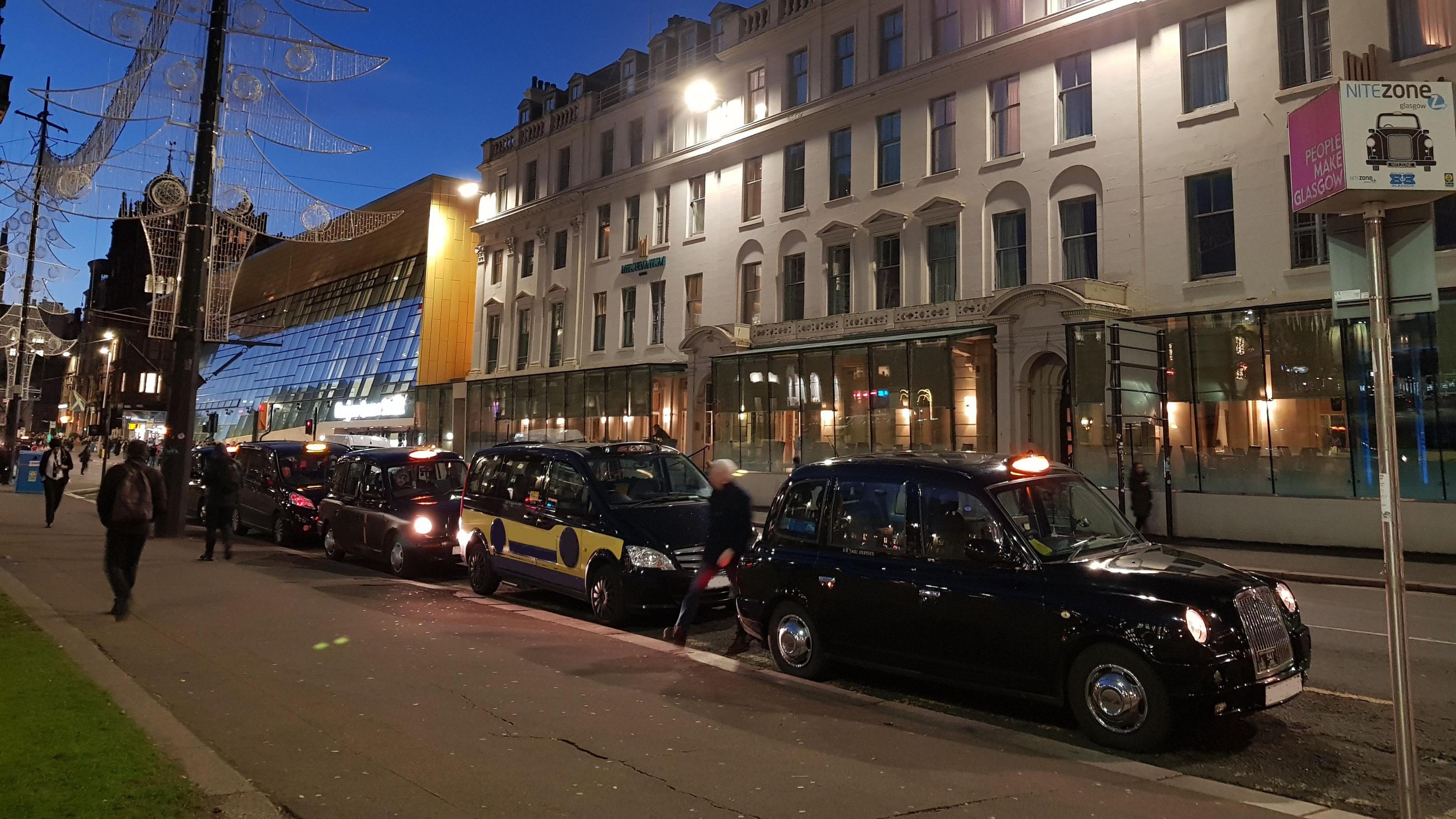 A row of black taxi cabs near Glasgow Queen Street train station