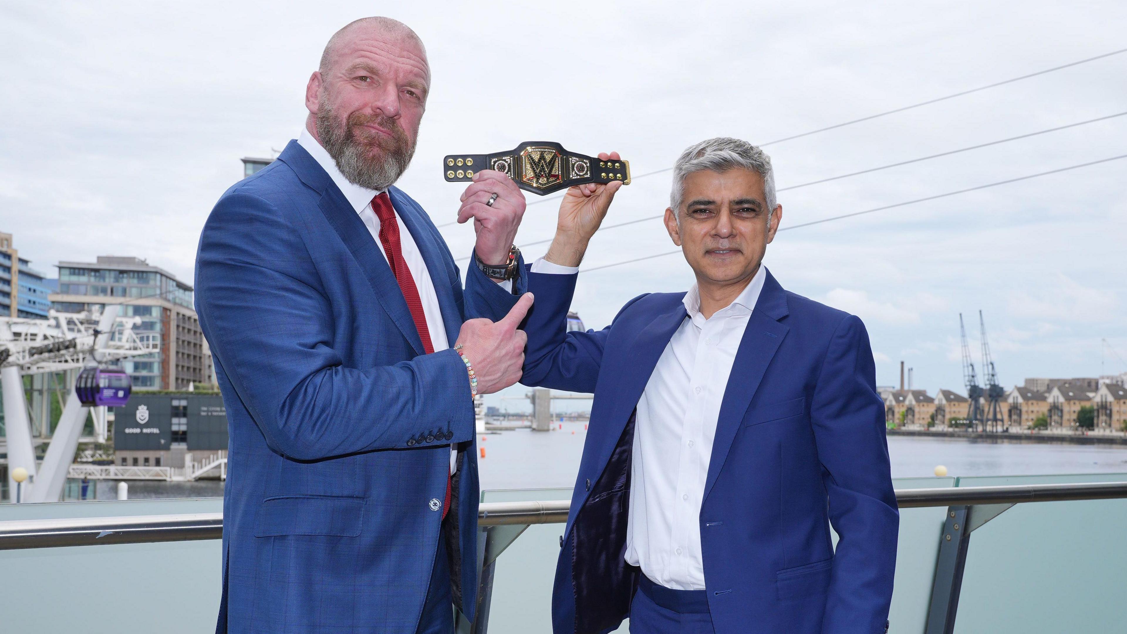 Mayor of London Sadiq Khan (right) holds aloft a gifted mini replica WWE Championship belt, with Paul "Triple H" Levesque, Head of Creative and Chief Content Officer, WWE, after a meeting at City Hall, London.