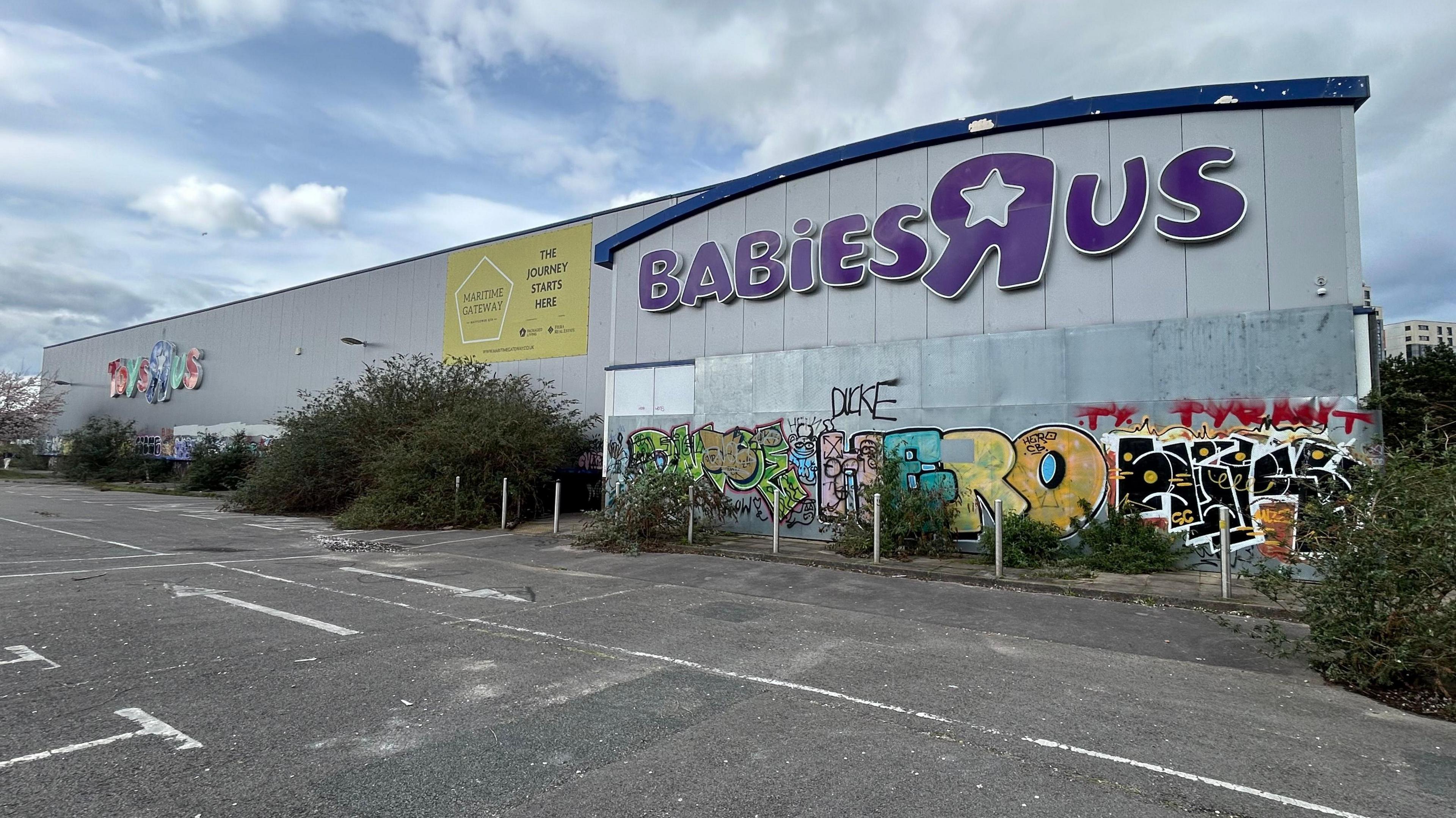 Southampton's former Toys R Us site - the building is derelict with graffiti and vegetation growing wildly around the building and its car park.