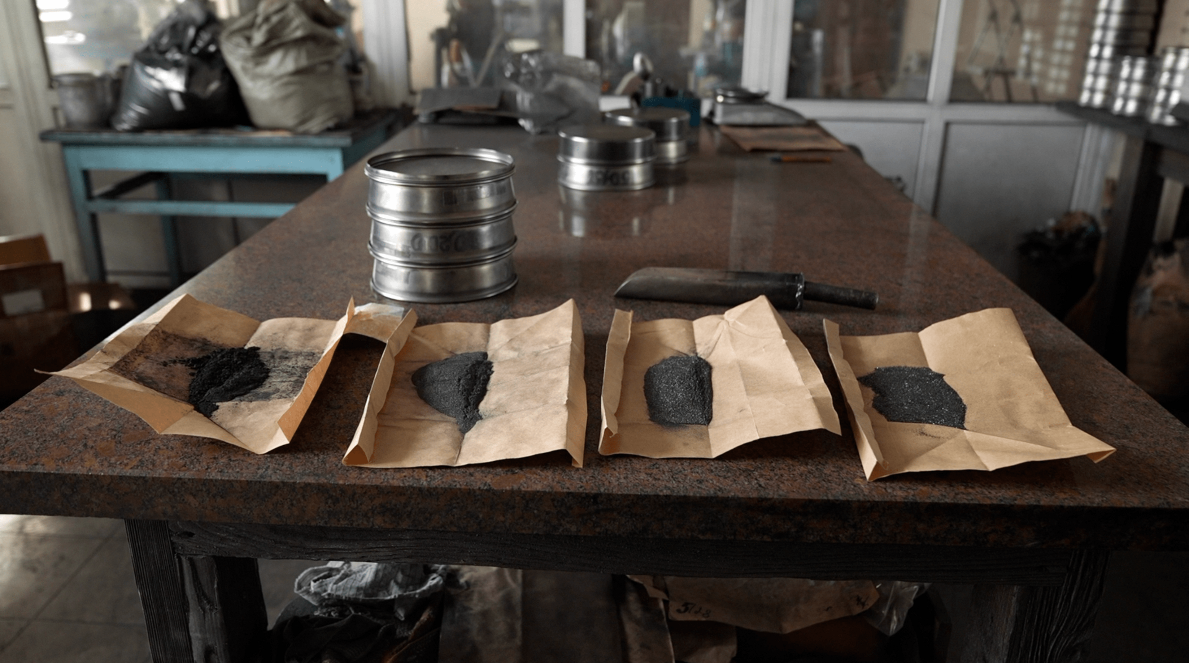 Samples of graphite on pieces of paper on a table