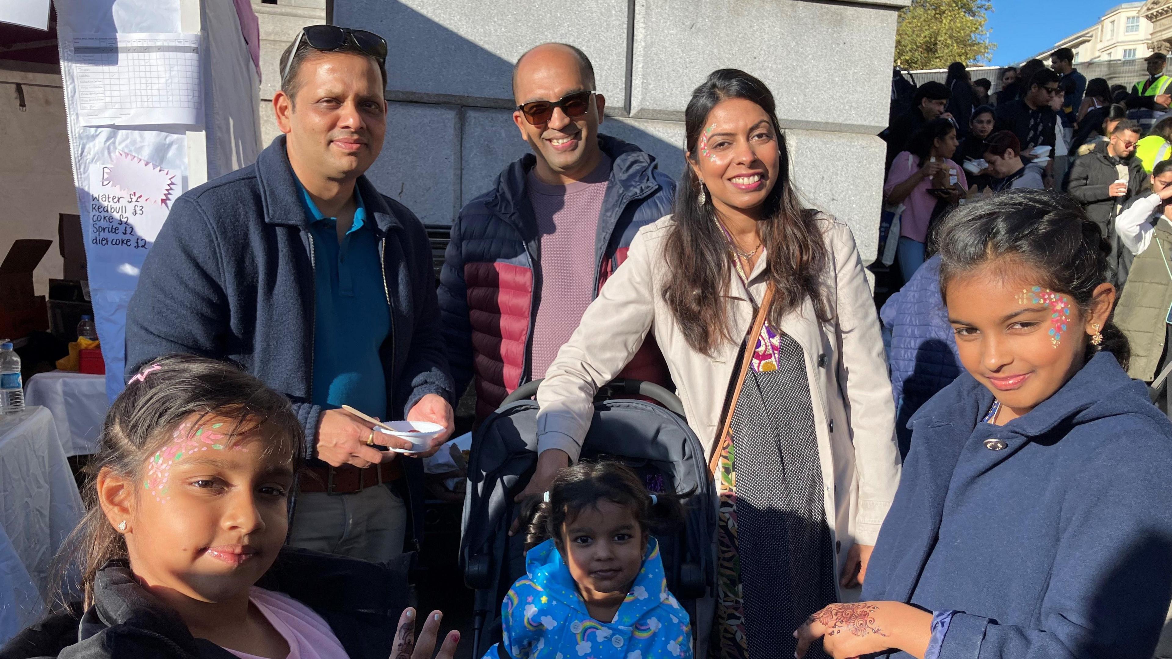 The Shah family, with Aira and Eva at the front of the picture and their parents and loved ones in the background