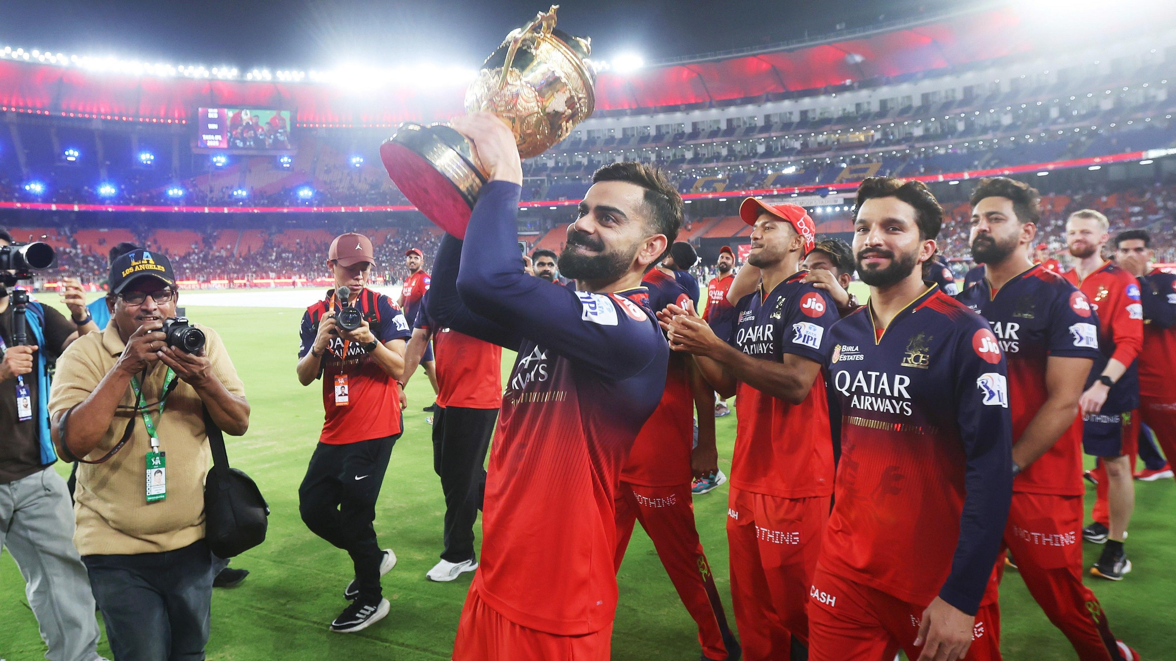 Virat Kohli and his RCB team-mates are photographed lifting the trophy