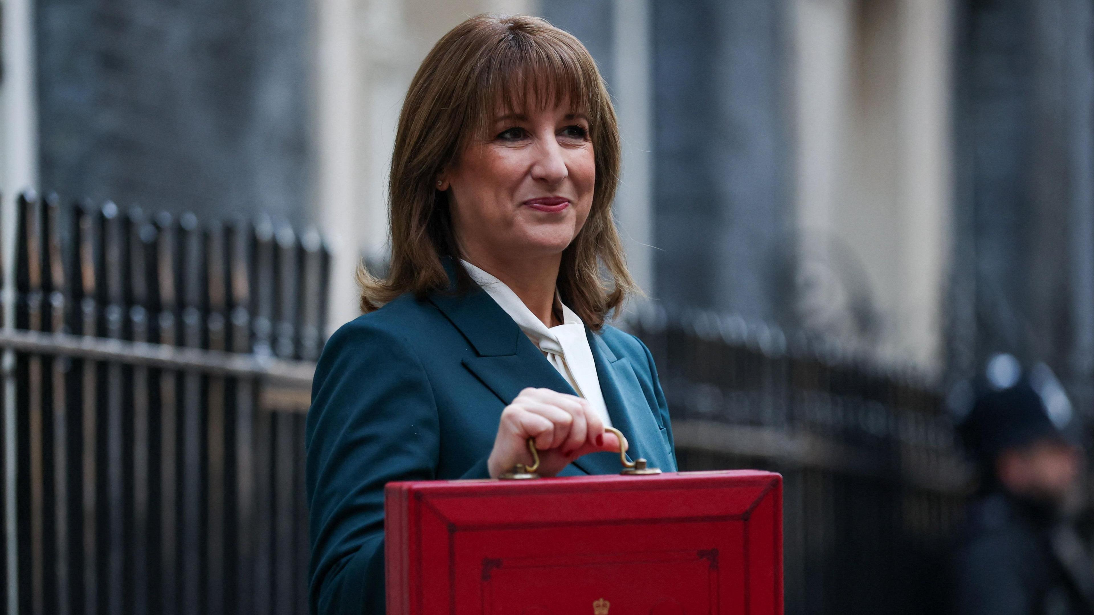 Chancellor Rachel Reeves standing in Downing Street with her Budget red box.