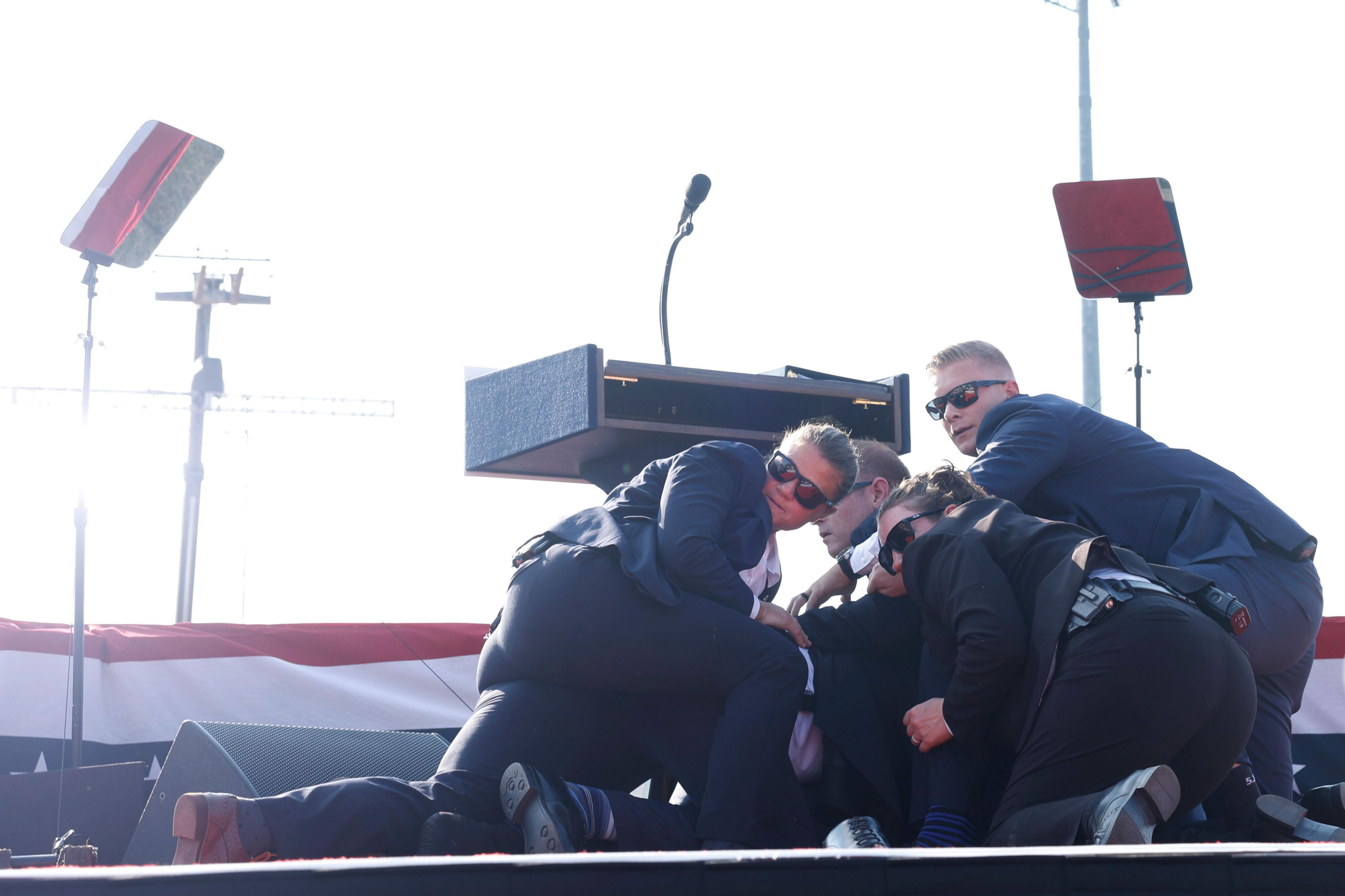 Members of the Secret Service rushed to cover Donald Trump after shots were fired.