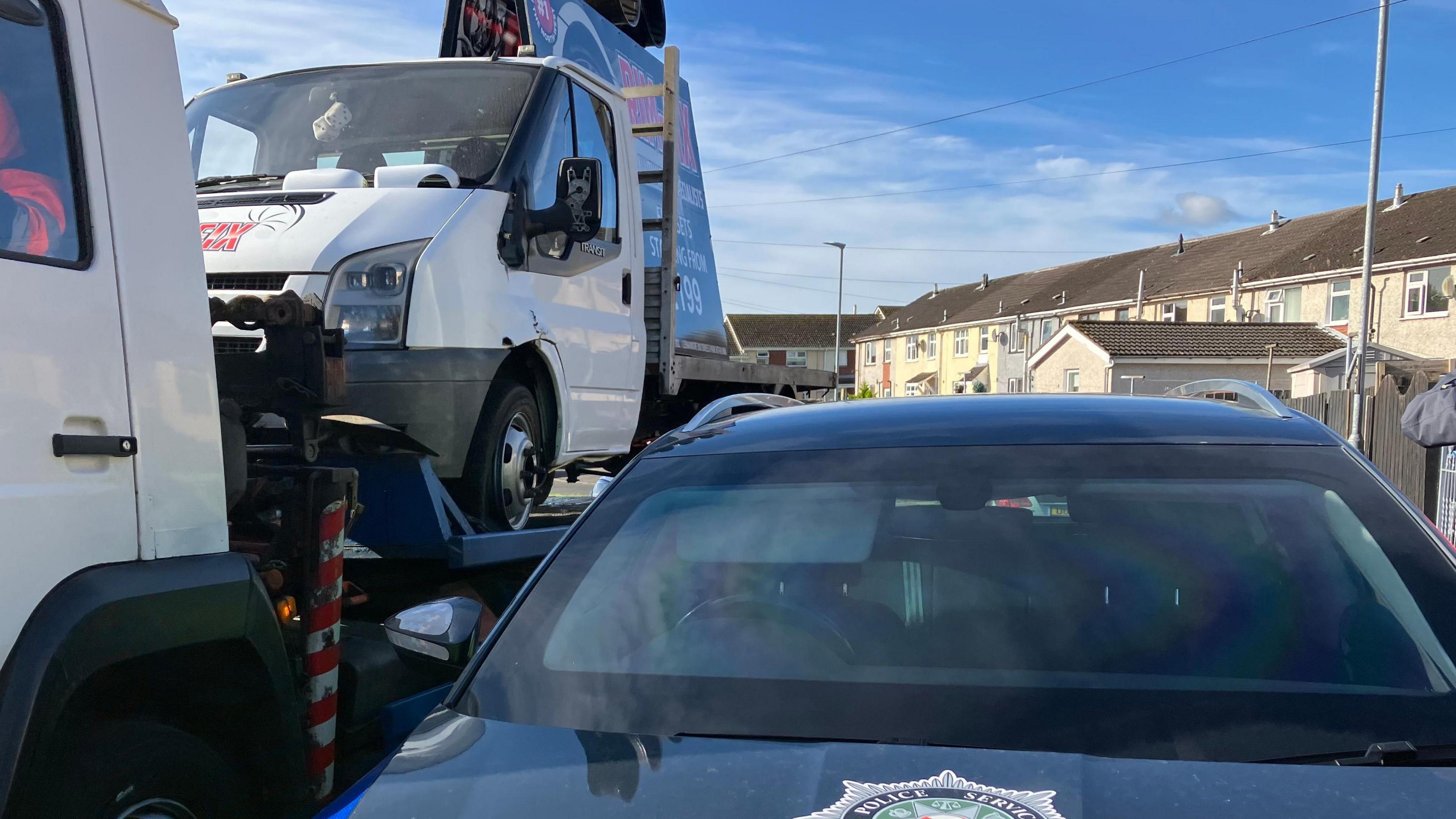 A van pictured on the back of a tow truck at the scene