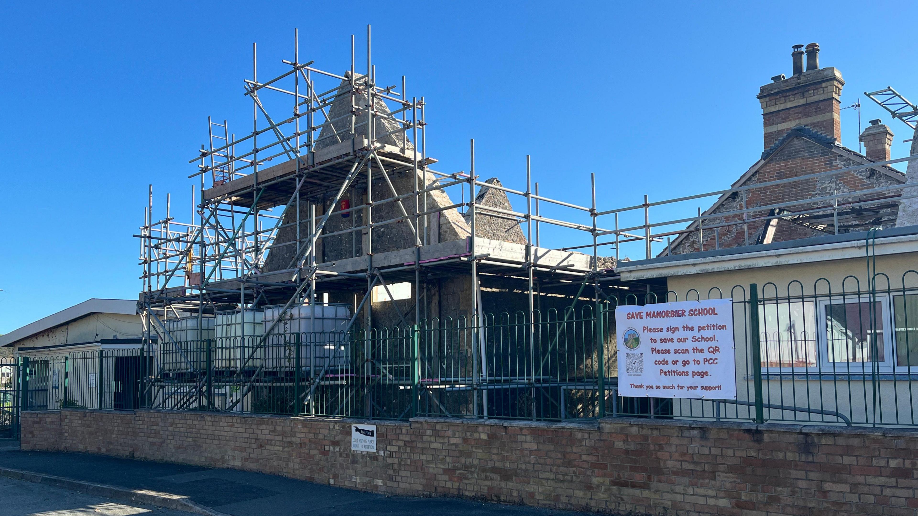 Manorbier VC School building with scaffolding visible, along with damage including a missing roof