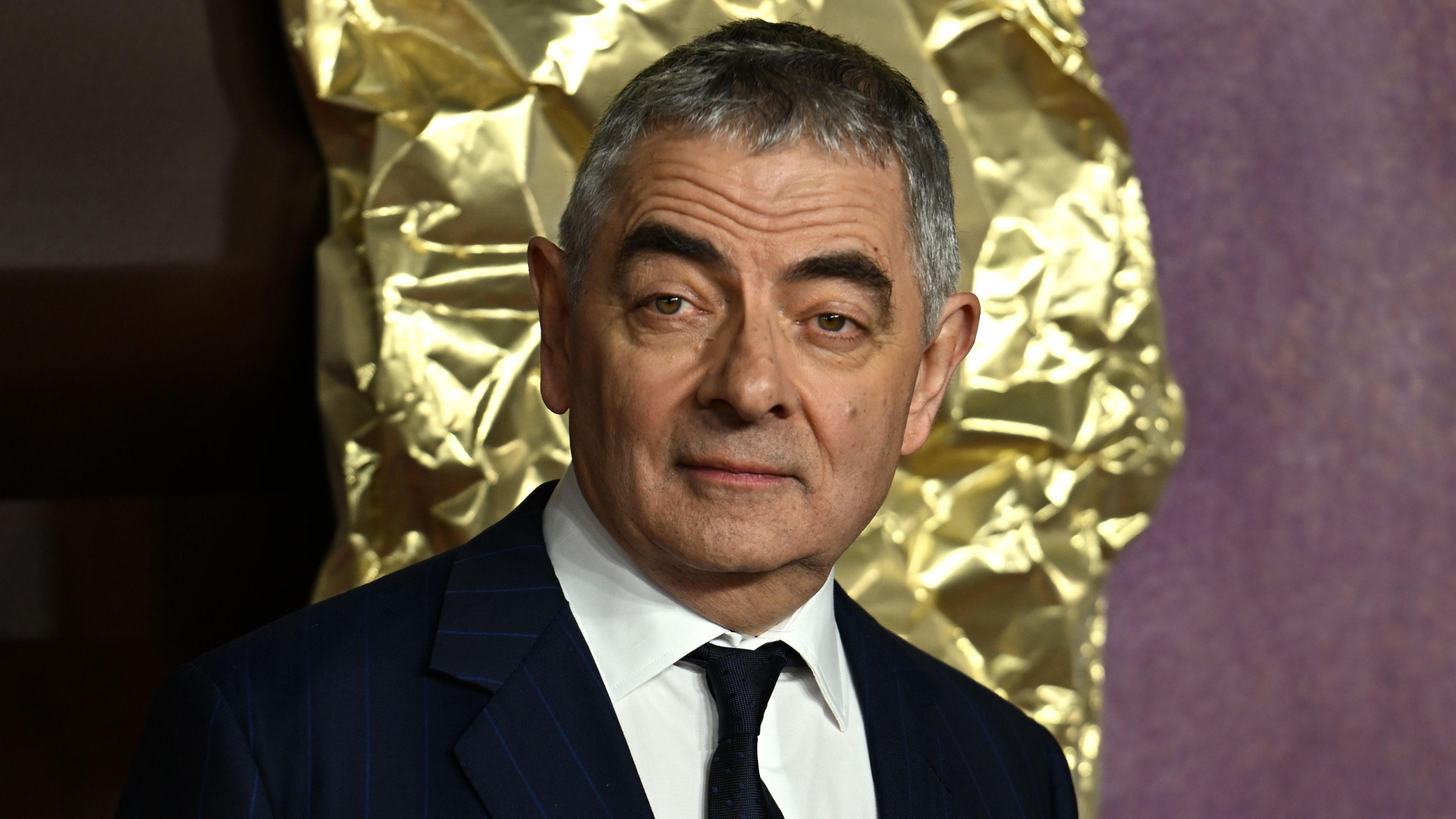 Actor Rowan Atkinson raises an eyebrow at the camera.