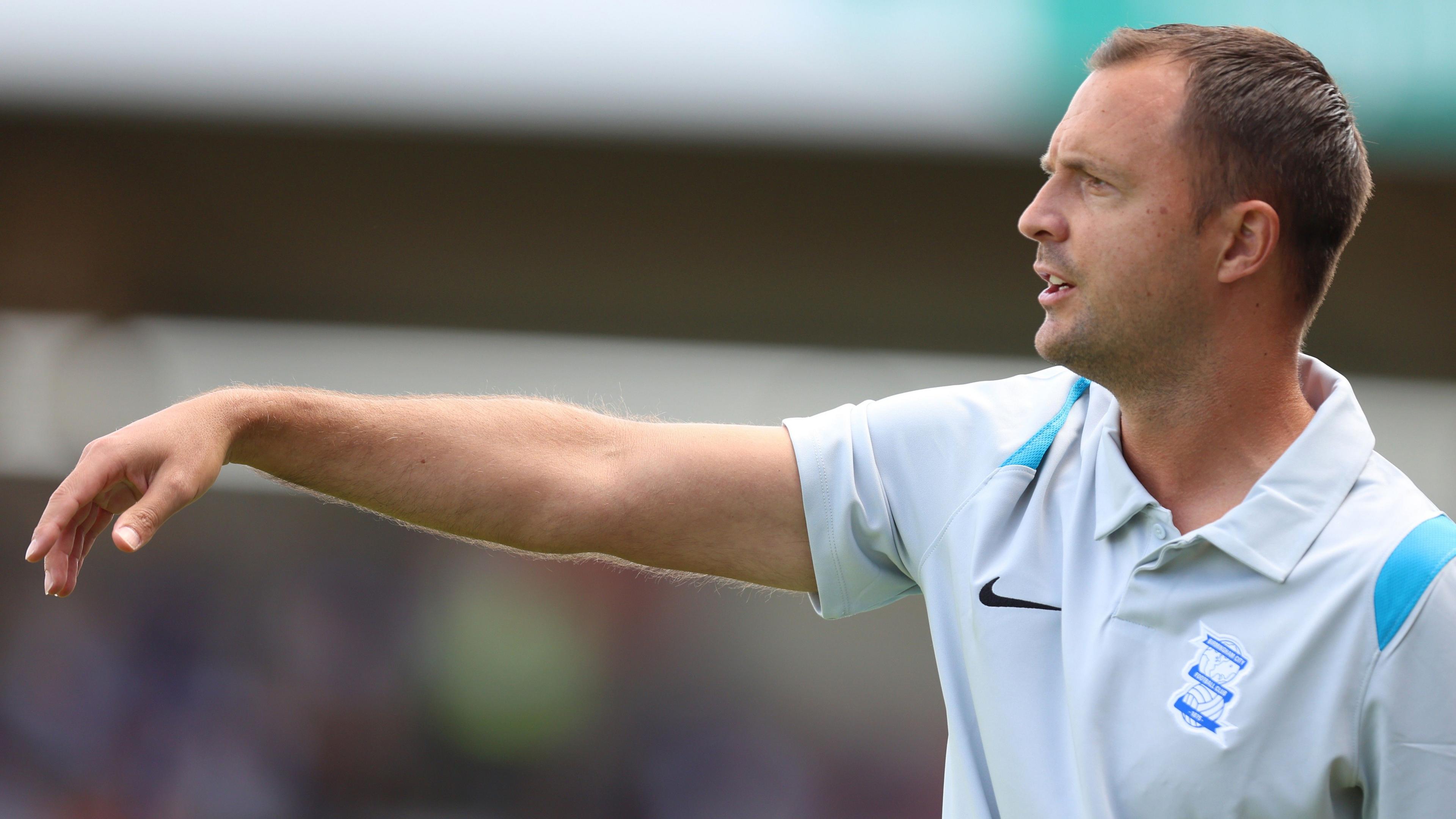 Chris Davies gestures from the touchline, wearing a grey polo shirt