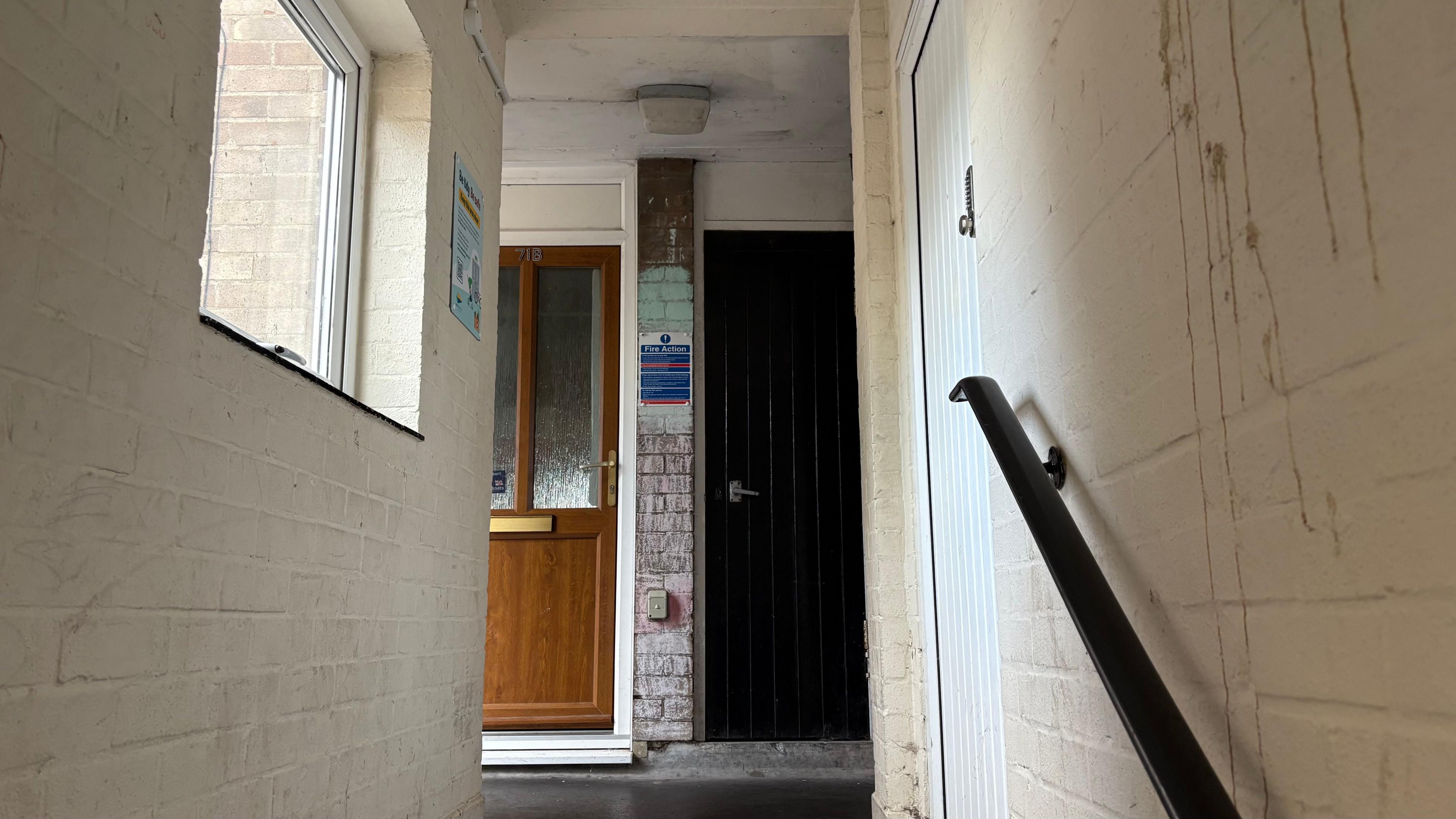 A view of a stairwell in the block. A dried liquid substance is on the white wall.