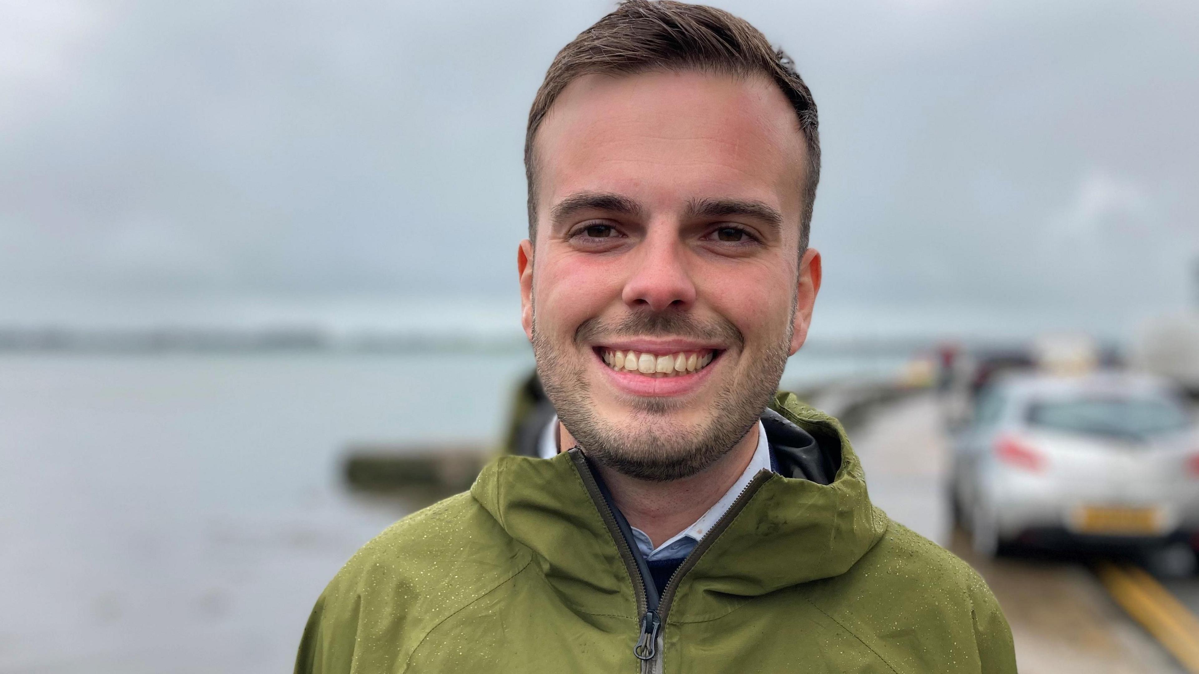 Gwynedd council's Dewi Jones smiles and wears a green zipped up jacket 
