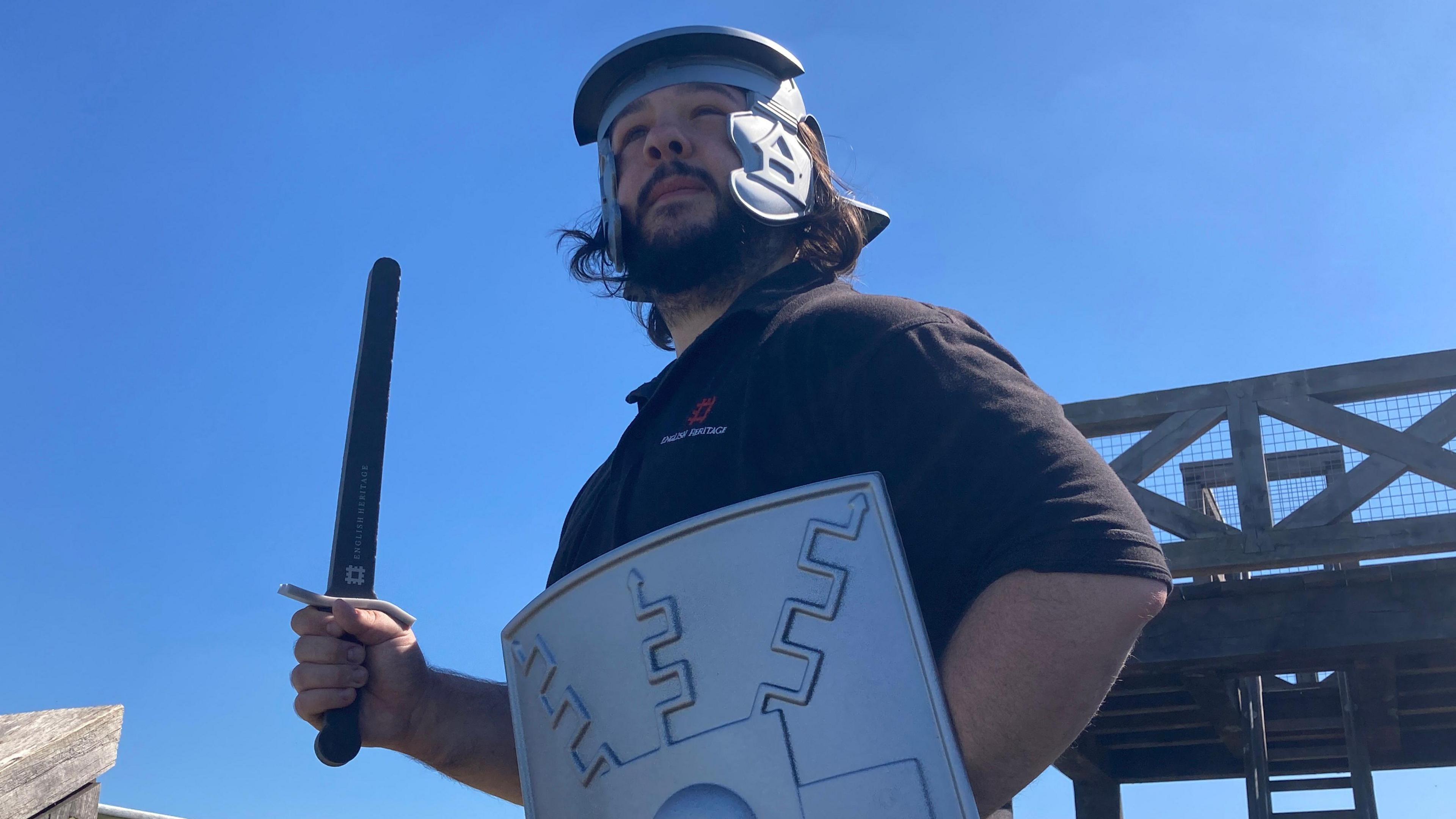 Tim Benfield in Roman helmet and holding a shield and sword