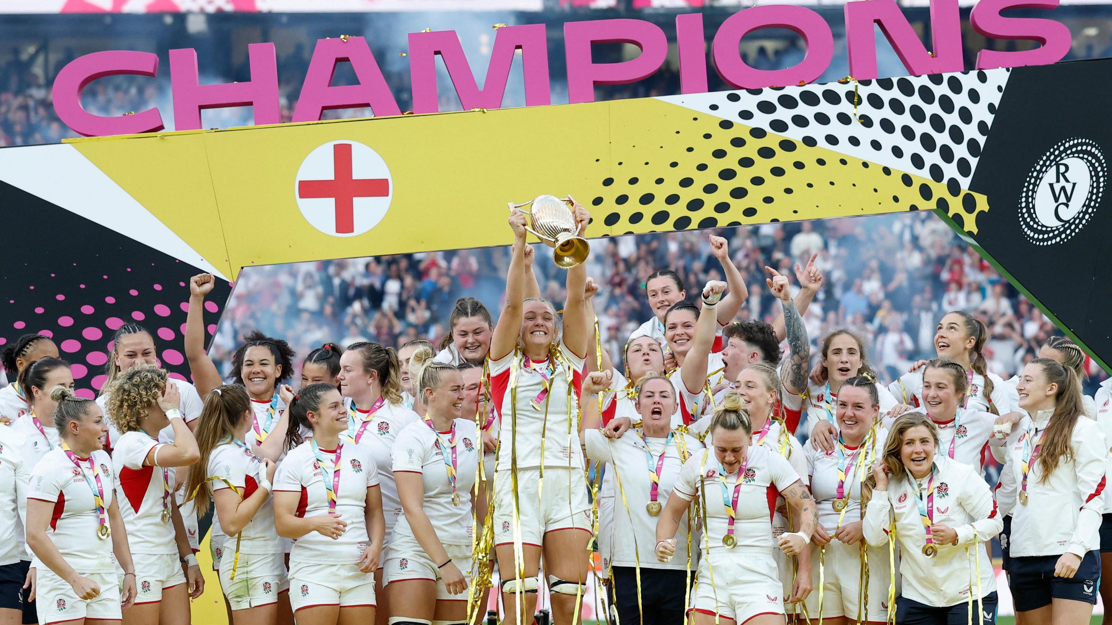 England's Zoe Aldcroft lifts the trophy as she celebrates with her teammates after winning the Women's Rugby World Cup final at Twickenham.