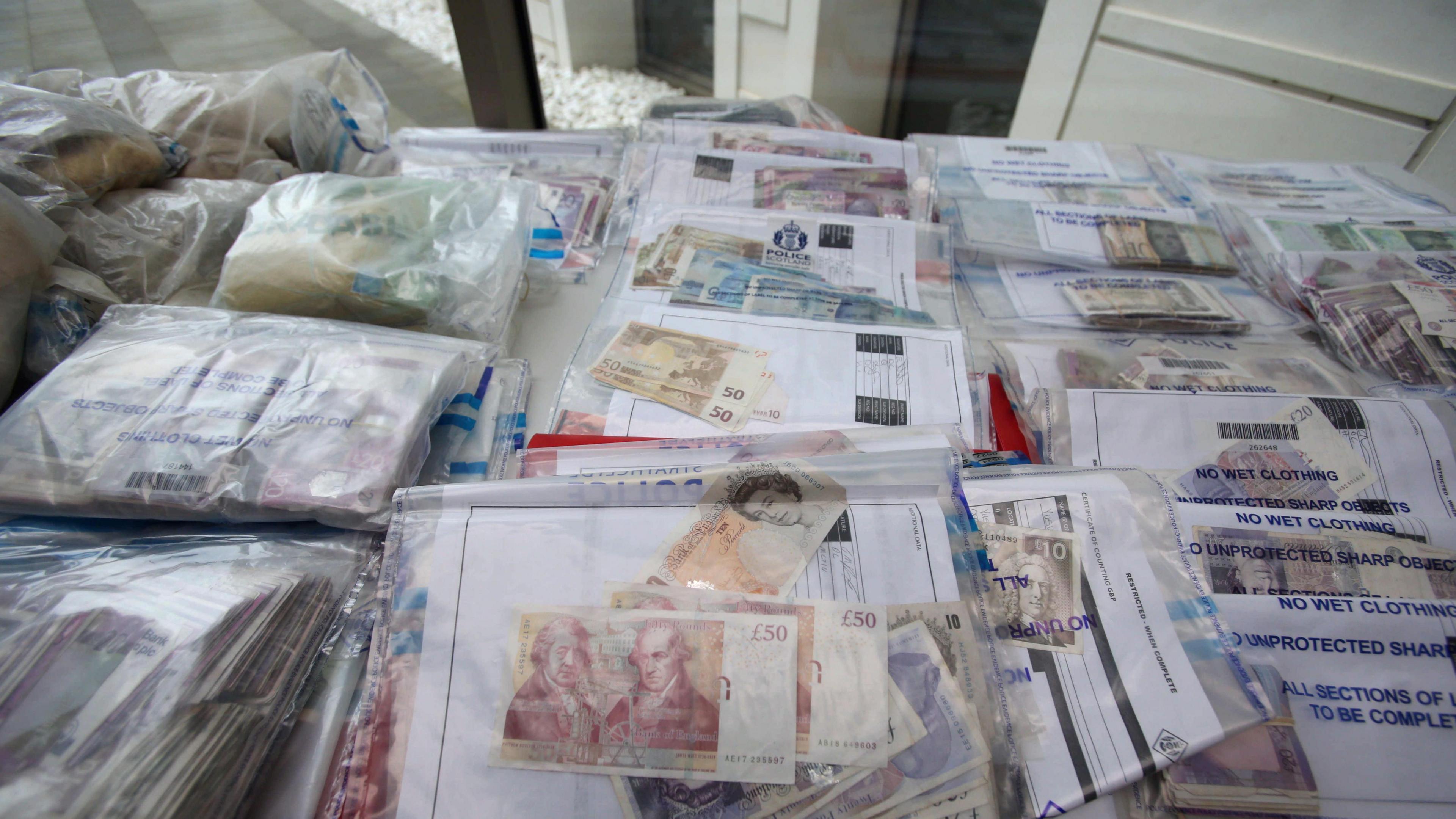 Cash seized in raids on display during a press briefing at the Scottish Crime Campus in Gartcosh, Lanarkshire.