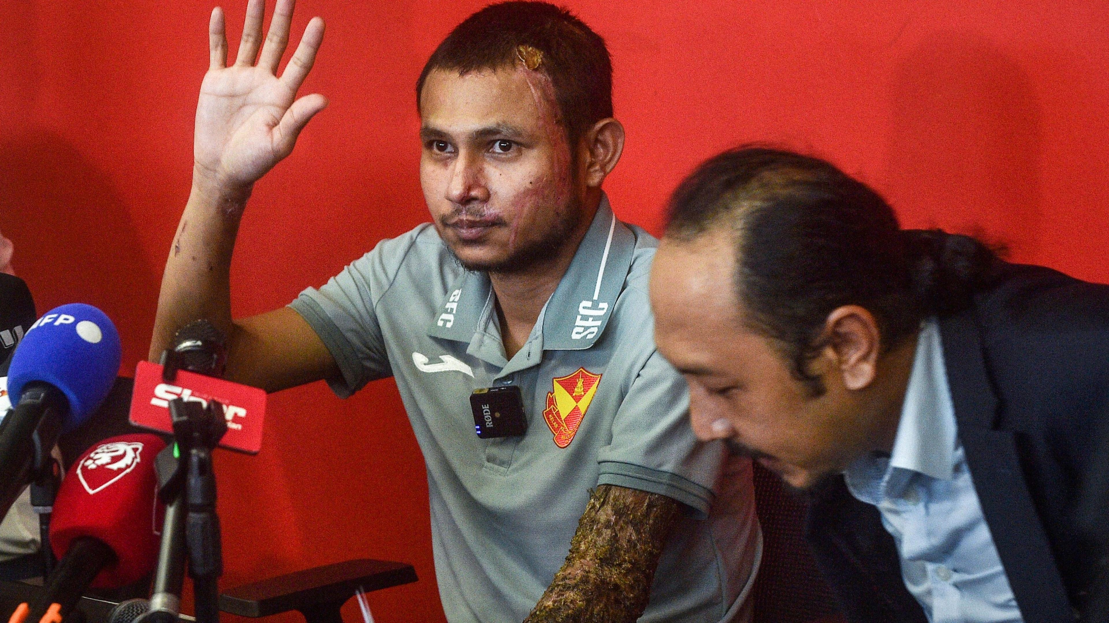 Malaysian national team and Selangor FC player Faisal Halim, who was severely injured in an acid attack, waves after a press conference in Shah Alam in Selangor on June 13, 2024