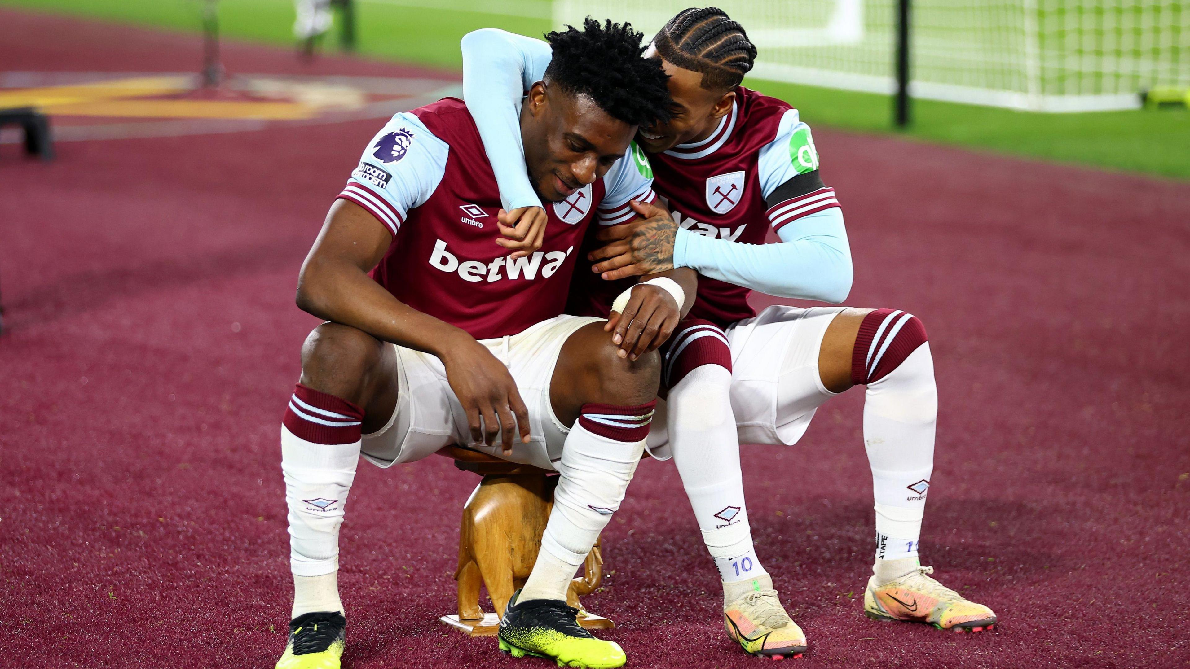 West Ham players Mohammed Kudus and Crysencio Summerville celebrate their goal by sitting on top of an wooden stool in the shape of an elephant