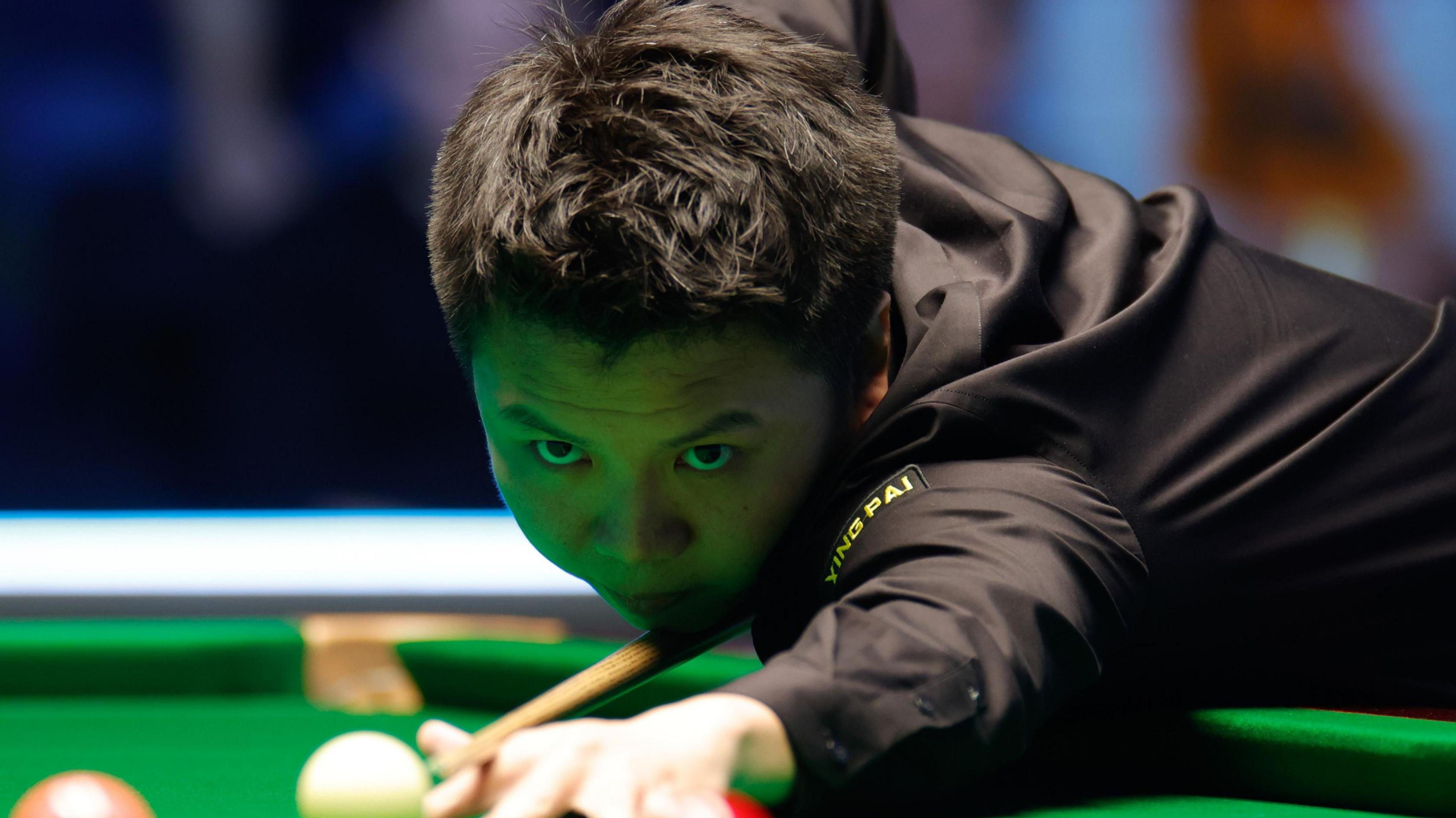 Zhou Yuelong plays a shot
