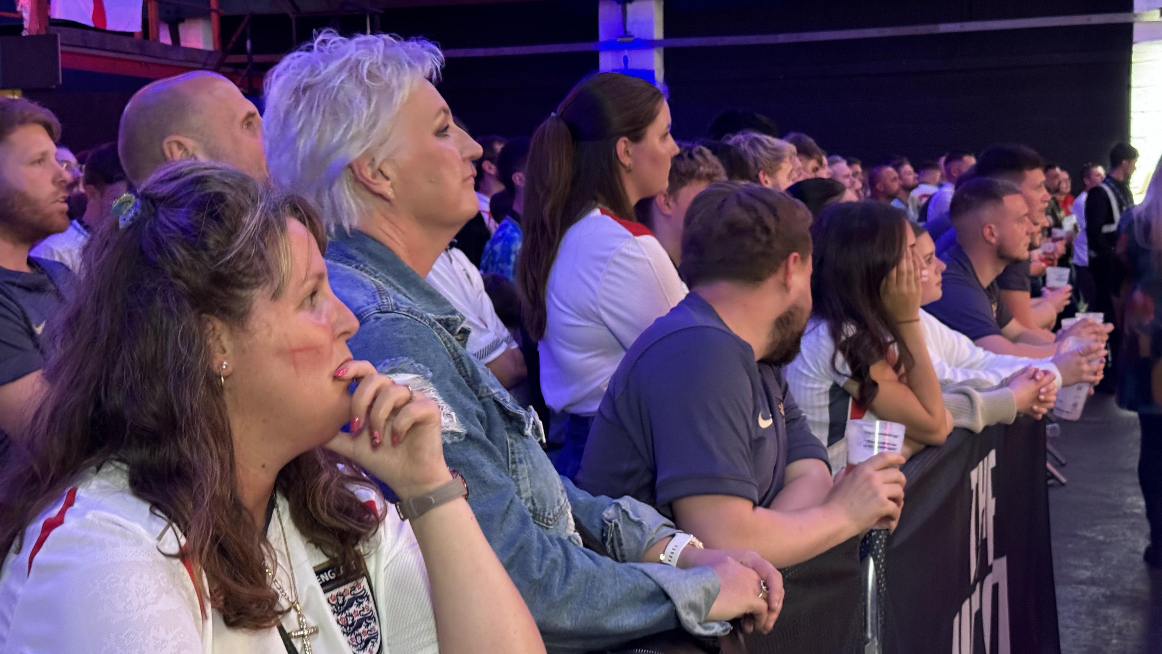 A crowd of men and women looking concerned