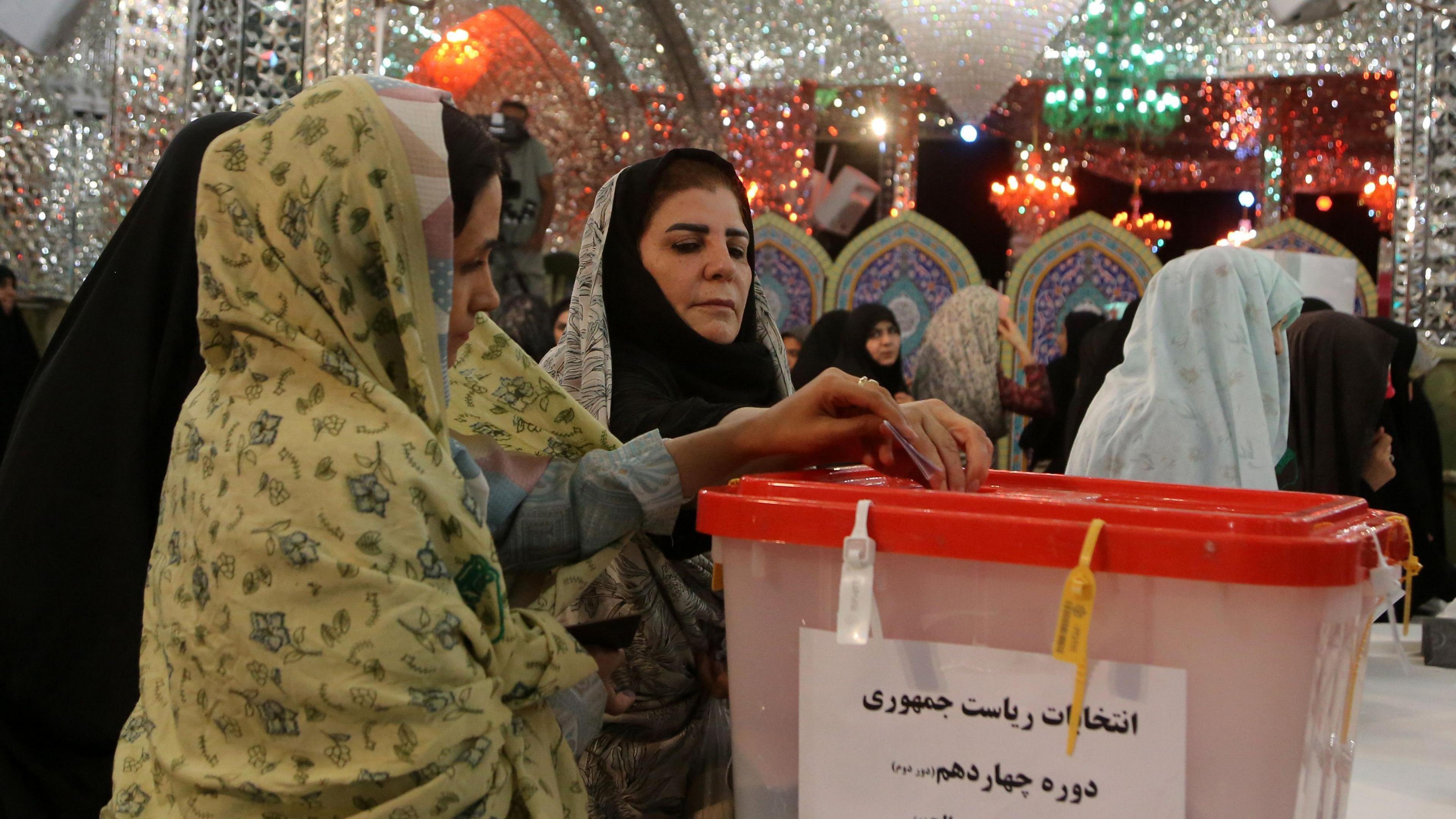 Iranian women casts their votes at a polling station in Tehran during the presidential election.