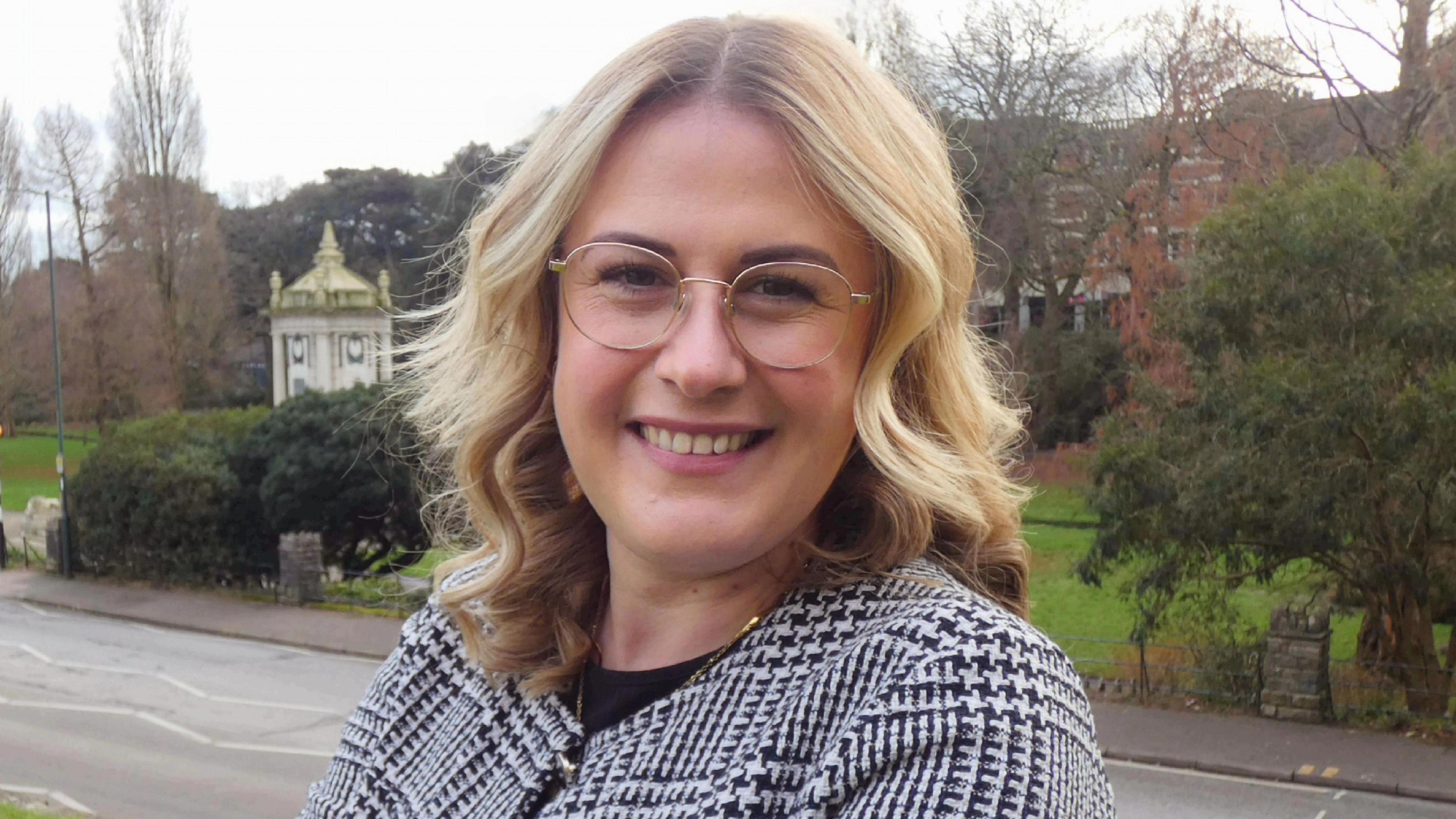 BCP Council leader Millie Earl. She has long blonde hair, glasses and is wearing a black and white patterned jacket.