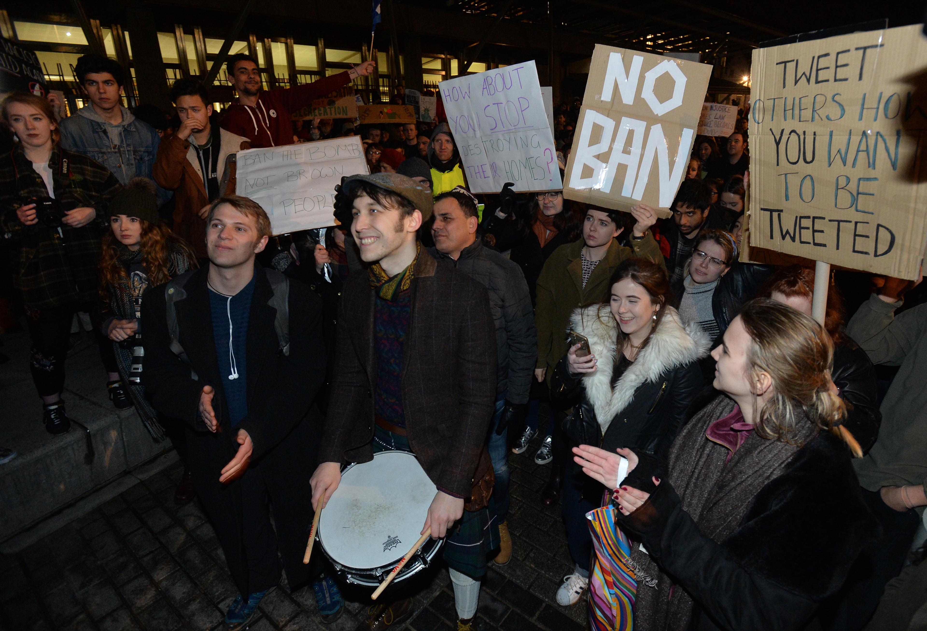 Demonstrators hold placards as they march from the Mound to the Scottish Parliament to protest against President Trump"s Muslim travel ban to the USA on January 30, 2017 in Edinburgh