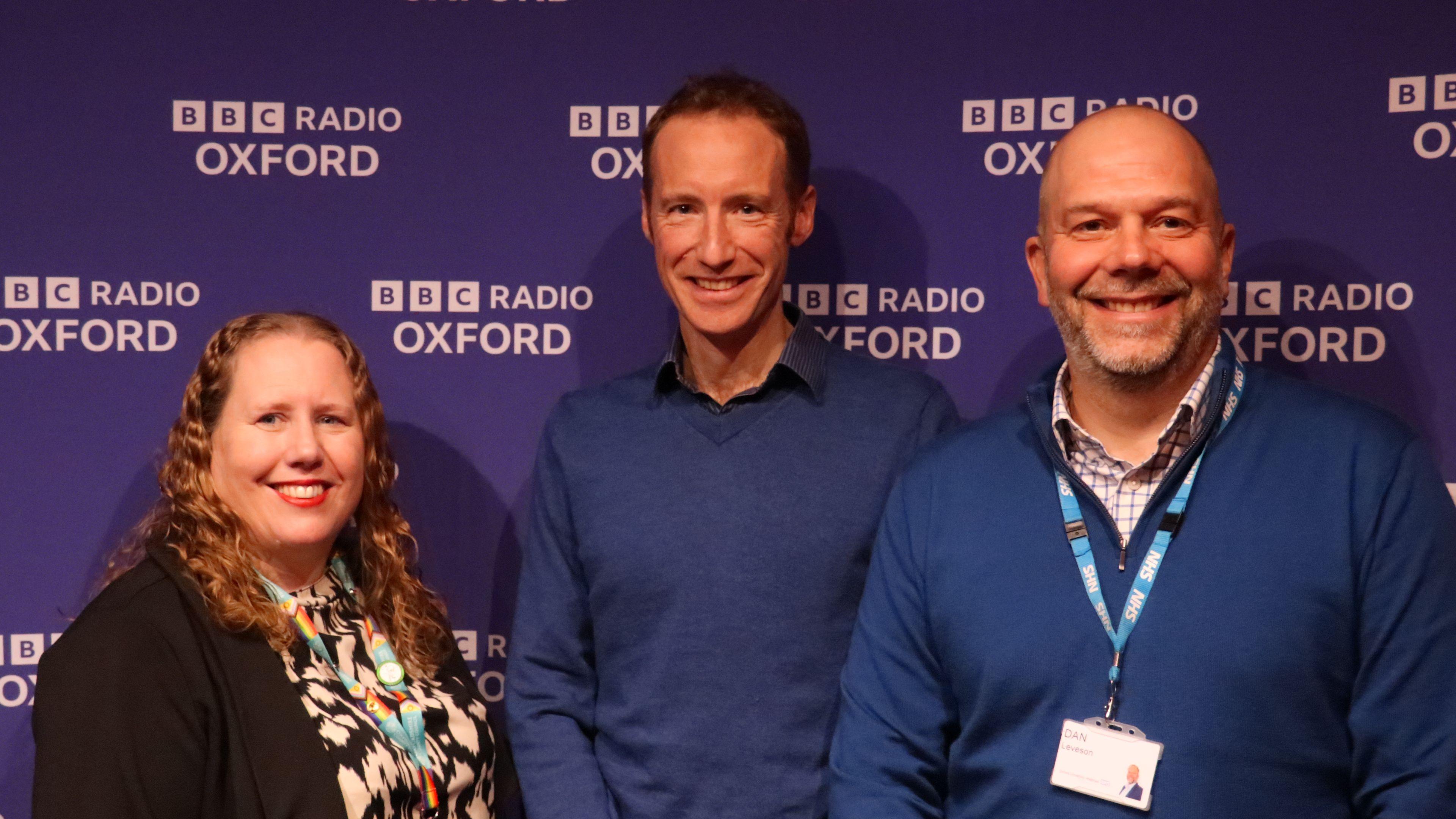 A picture Dan Leveson, Place Director for Oxfordshire at Buckinghamshire, Oxfordshire and Berkshire West Integrated Care Board (BOB ICB); Dr Ed Capo Bianco a GP at Goring & Woodcote Medical Practice and clinical lead for urgent care, palliative and end of life care and cardiovascular disease in Oxfordshire at BOBICB and Karen Fuller Oxfordshire County Council’s Director of Adult Social Care. They are standing in front of a purple background with BBC Radio Oxford branding on it. 
 
