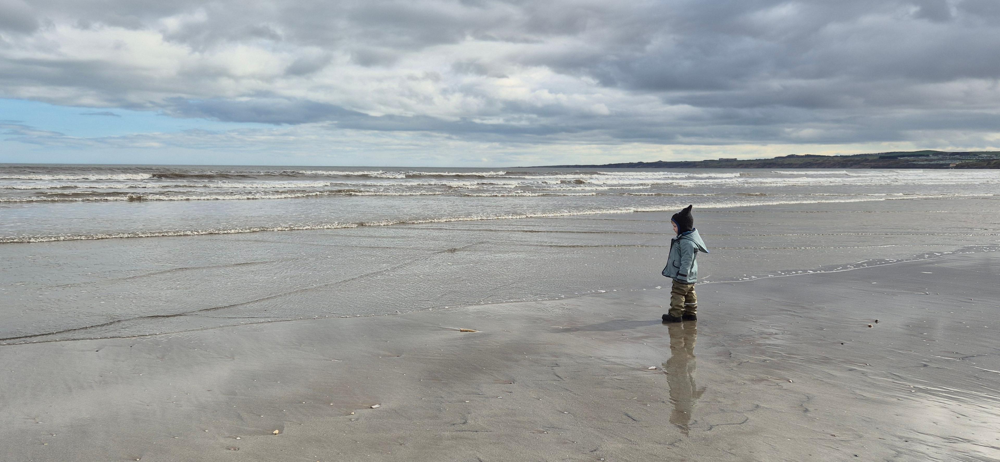 Young boy standing on a beach