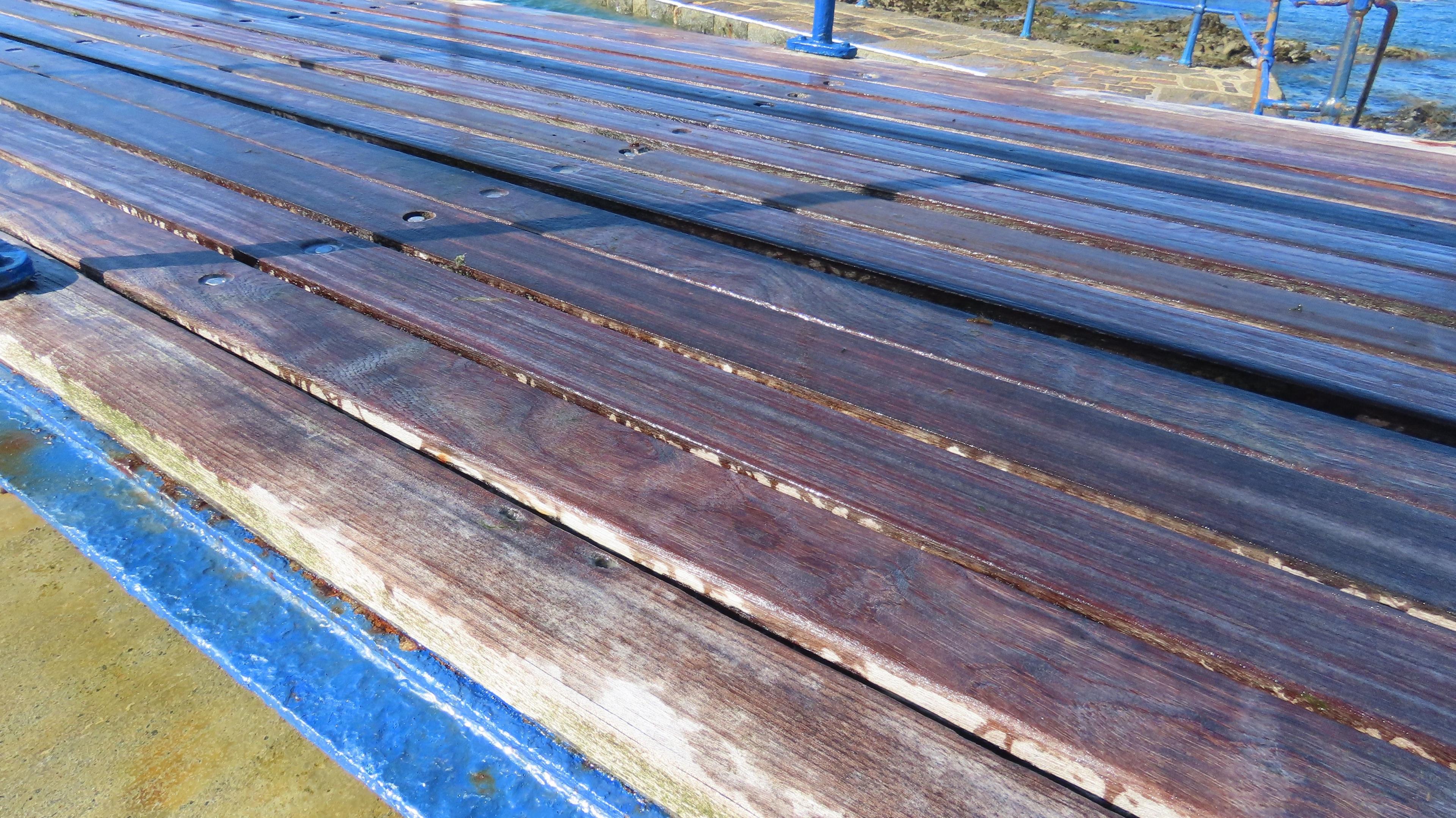 The diving board at La Vallette close up. Wooden strips with blue metal on ythe outside.