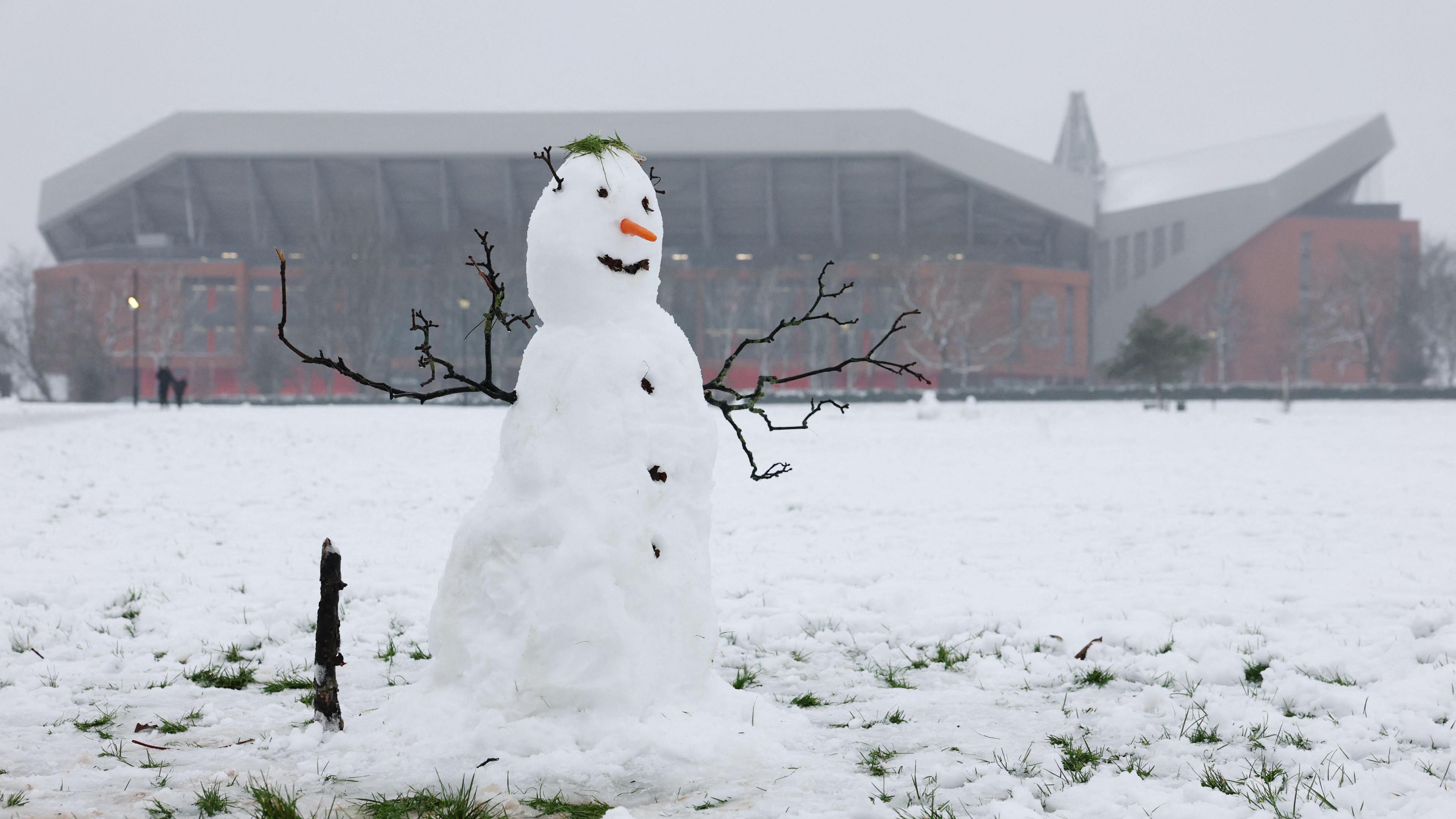 A snowman is seen outside Anfield before the match against Manchester United. Snow can be seen all around the ground. 