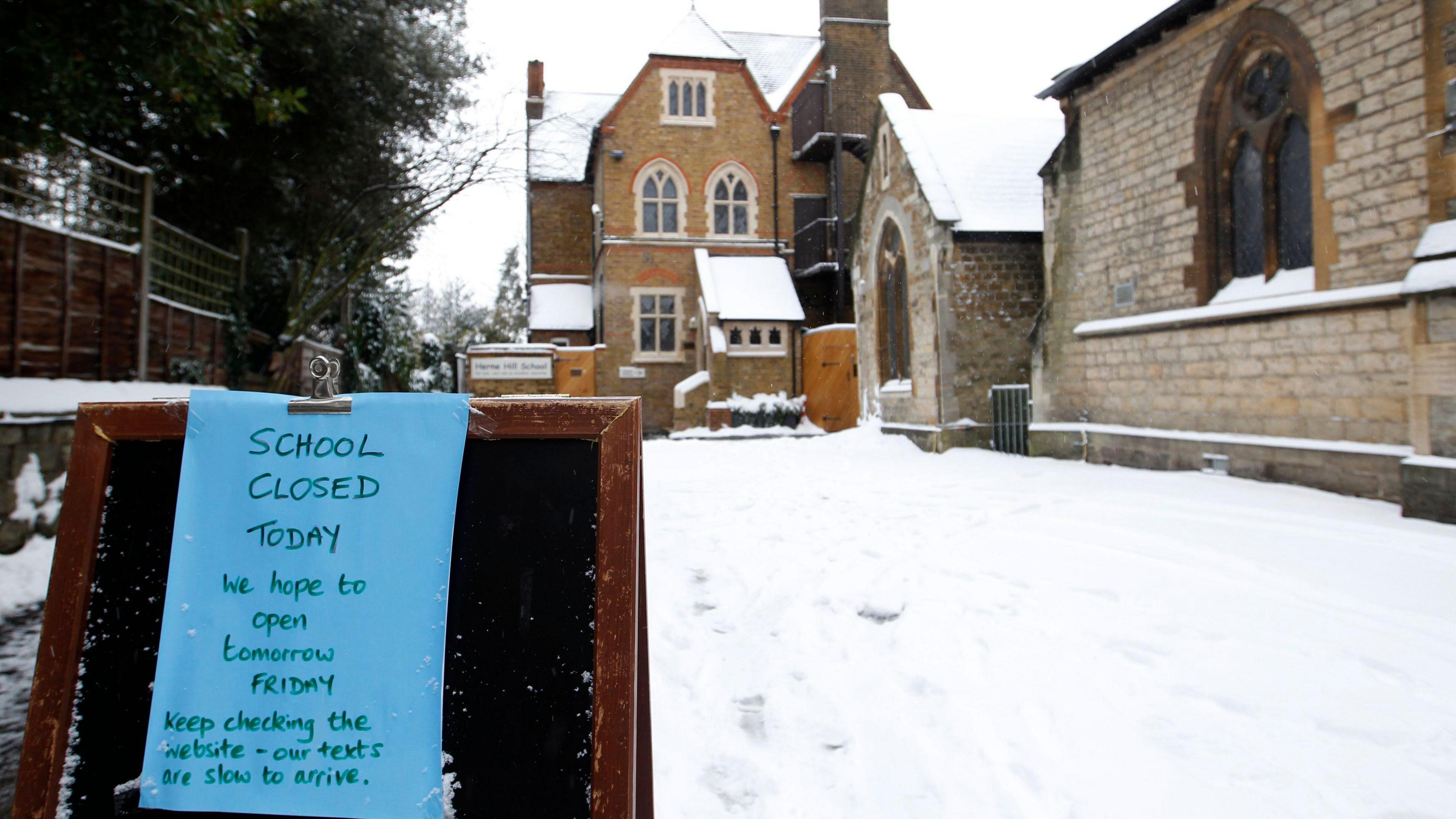 Sign against a snowy background saying that school is closed today