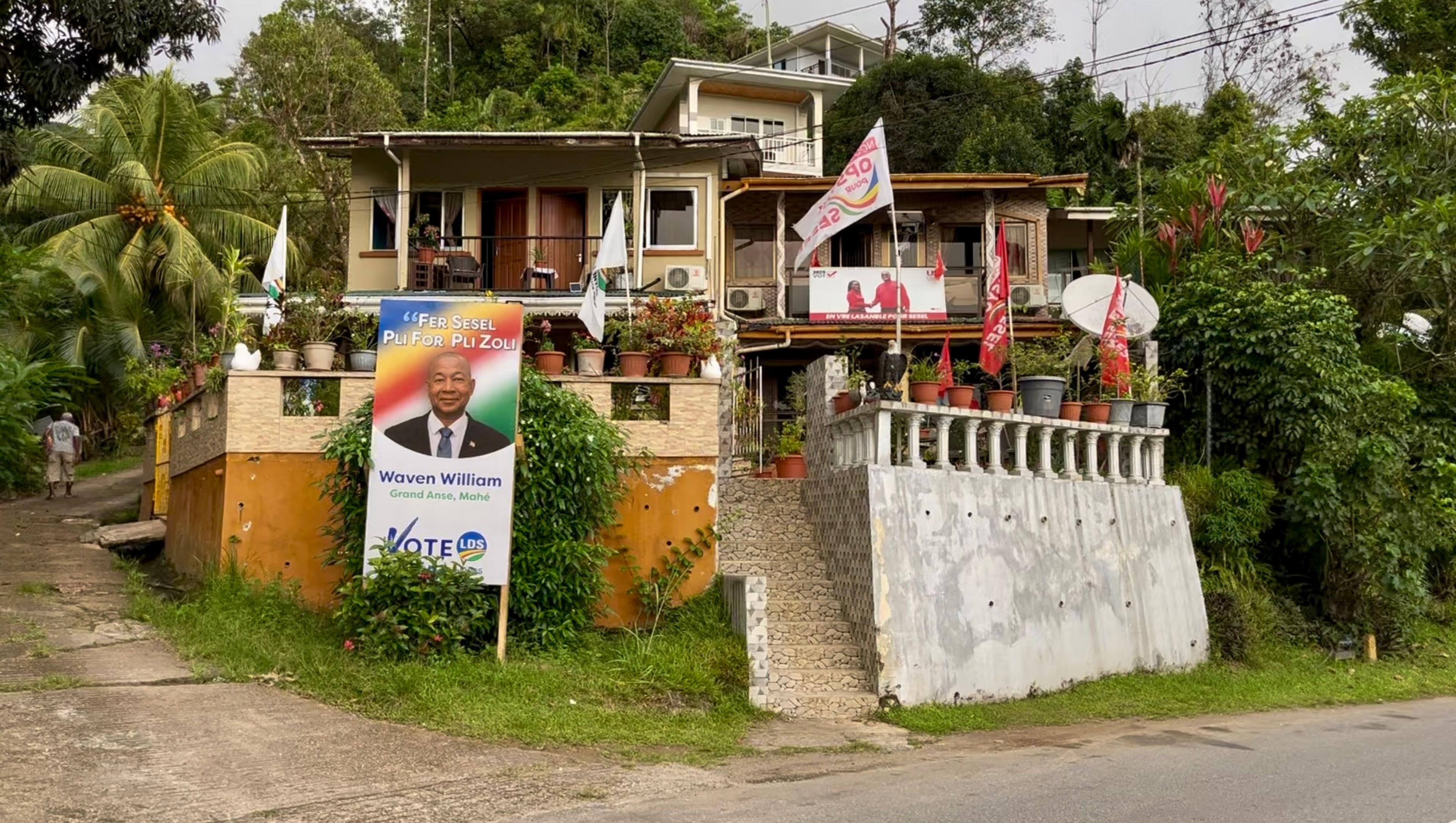 Two neighbouring houses display placards showing support for opposing political parties.