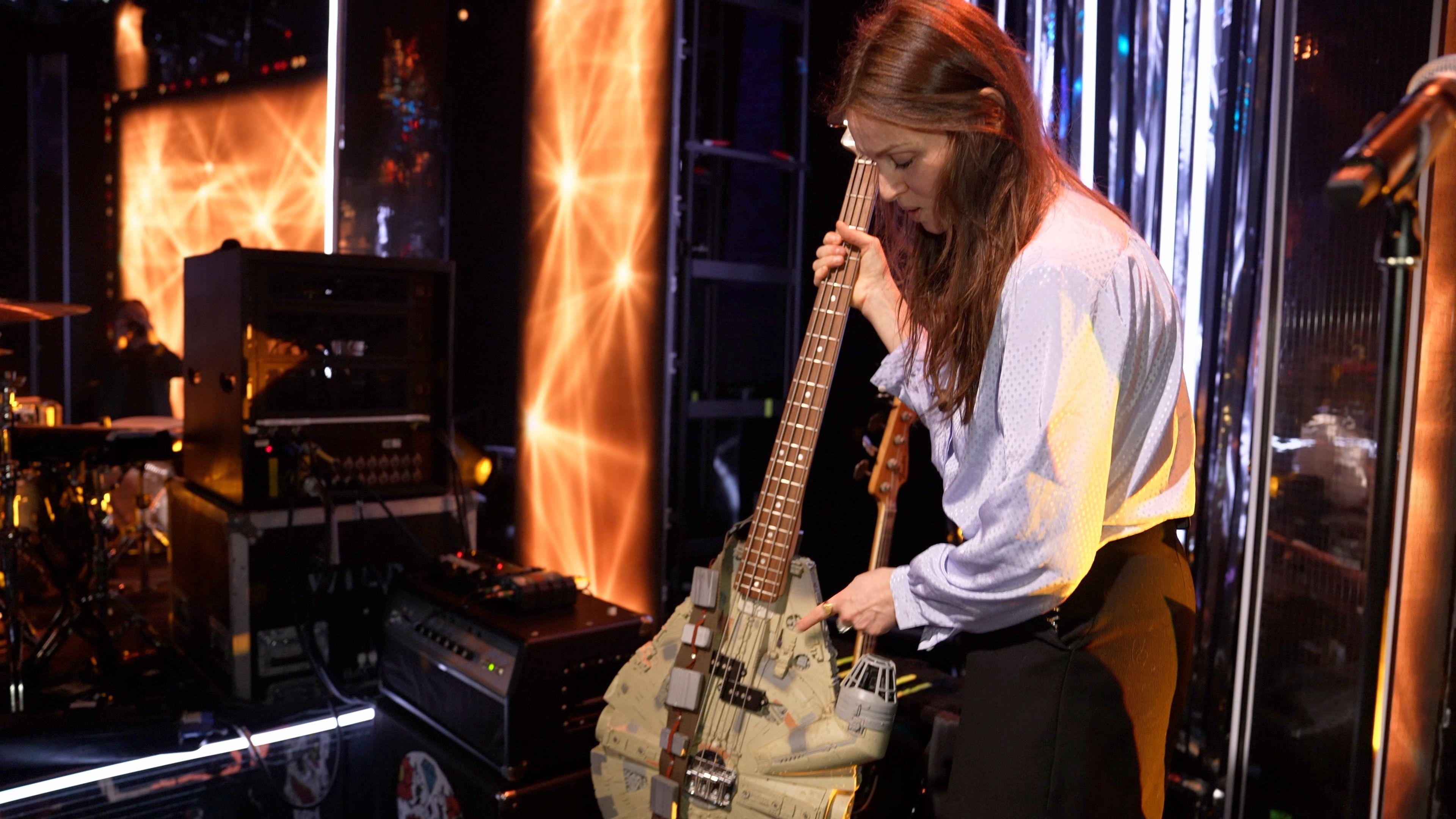 Sophie Ellis-Bextor holding a bass guitar which has been made from a Millennium Falcon Star Wars toy.