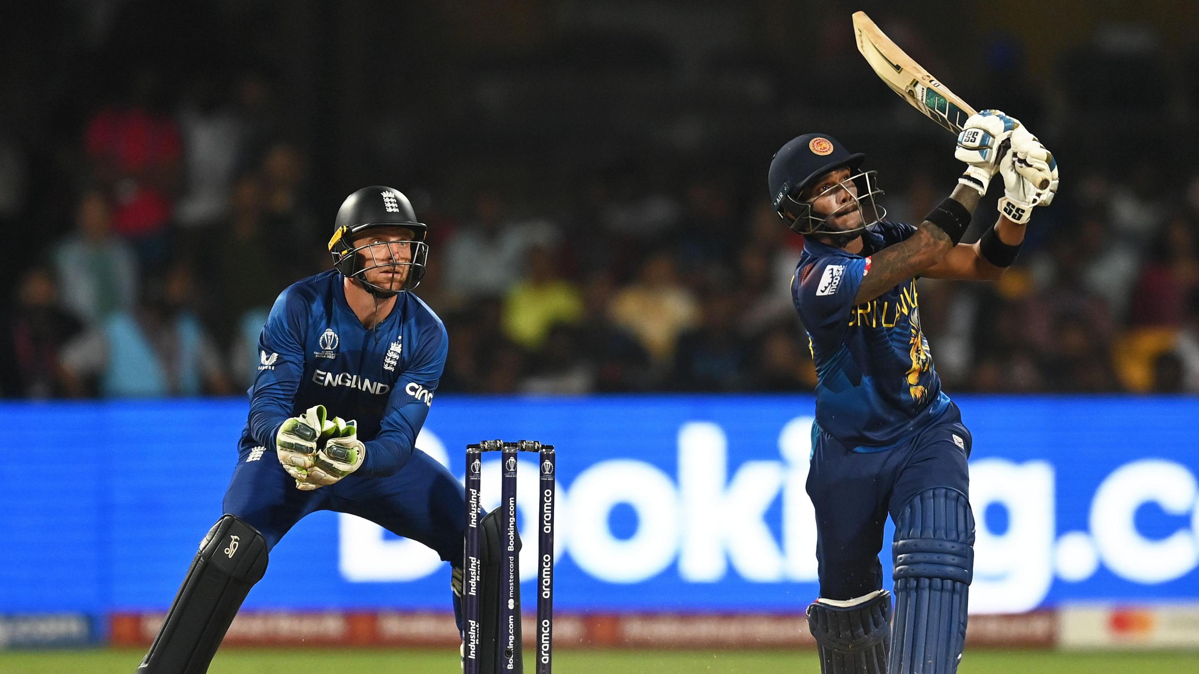 Sri Lanka batter Pathum Nissanka hits out, watched by England wicketkeeper Jos Buttler, in 2023