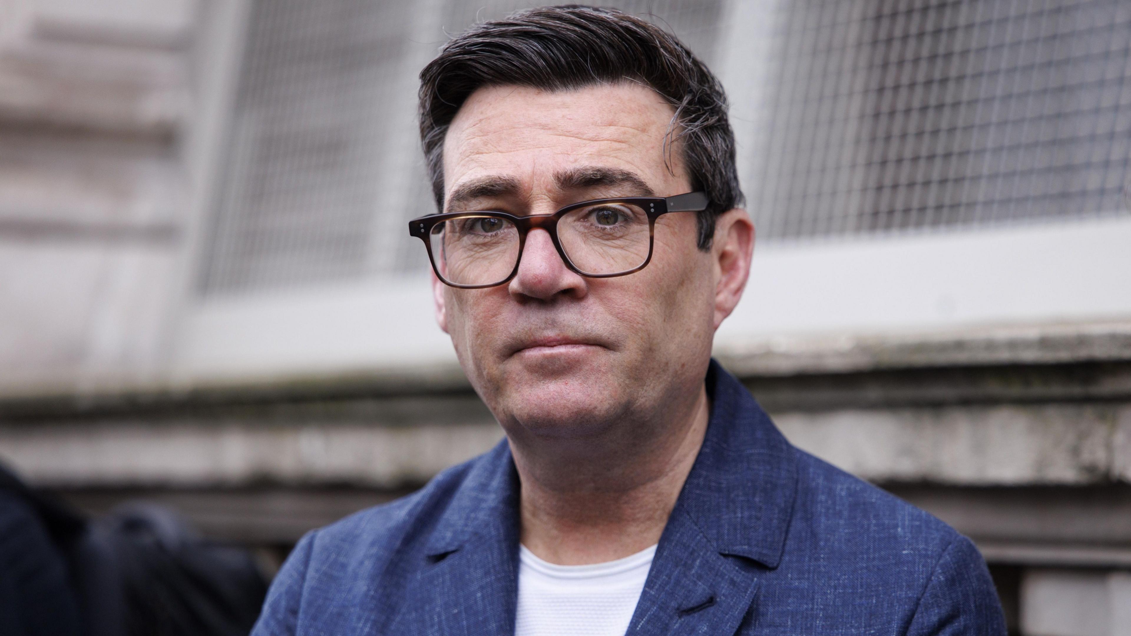 Andy Burnham, wearing a blue blazer and white tshirt