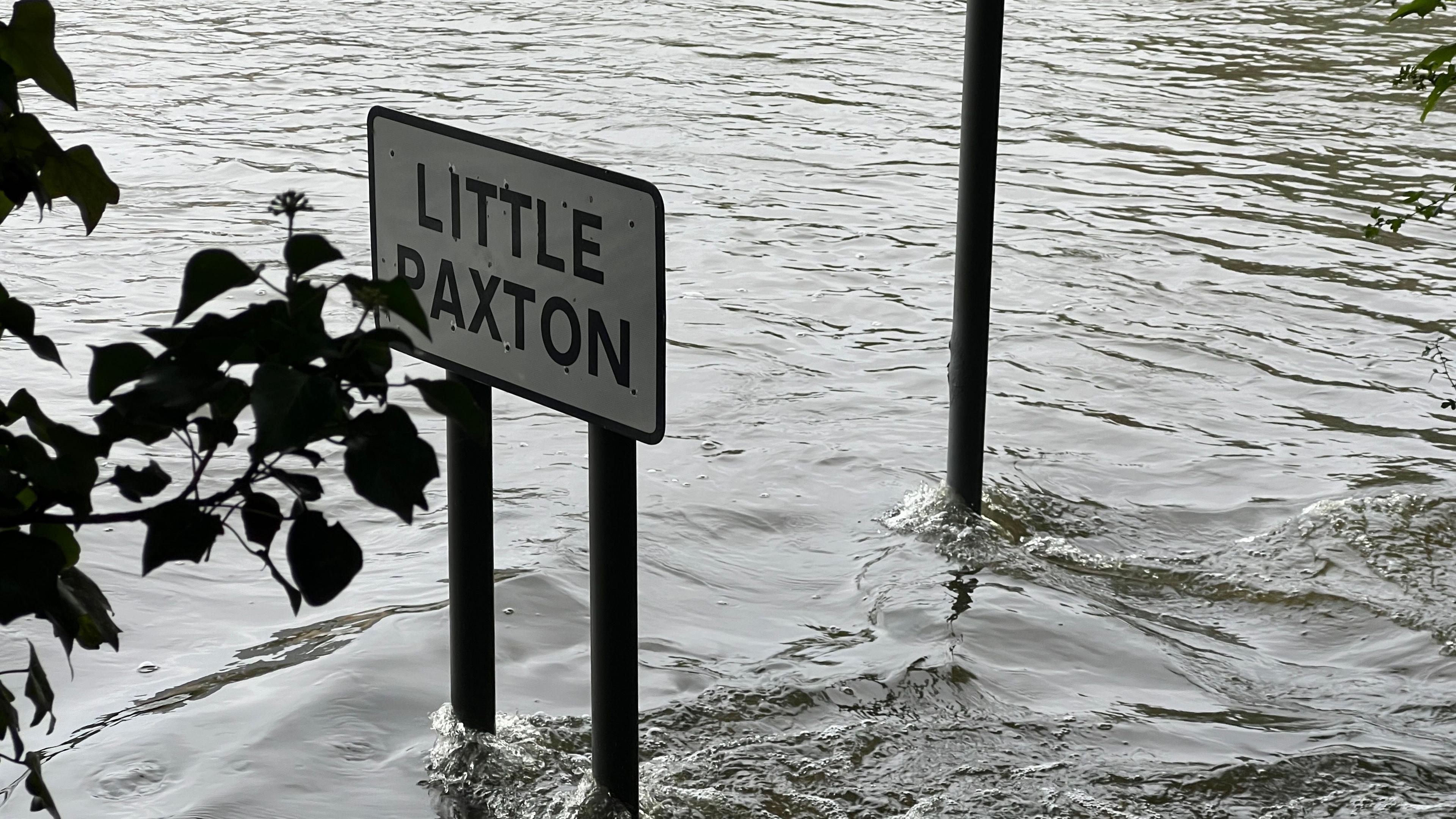 A Little Paxton road sign sticking out of the flood water. 