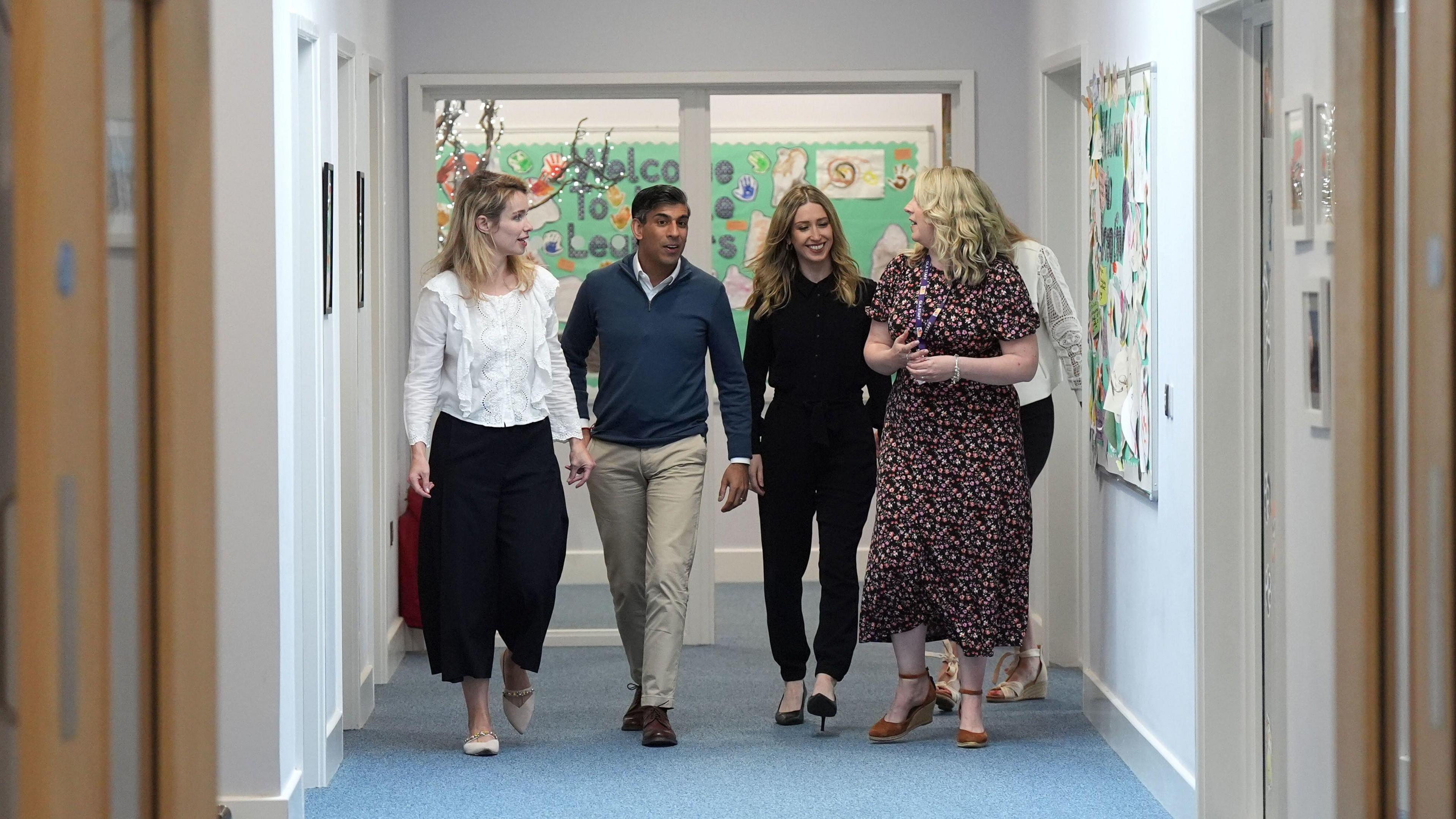 Rishi Sunak walks down a corridor in a primary school