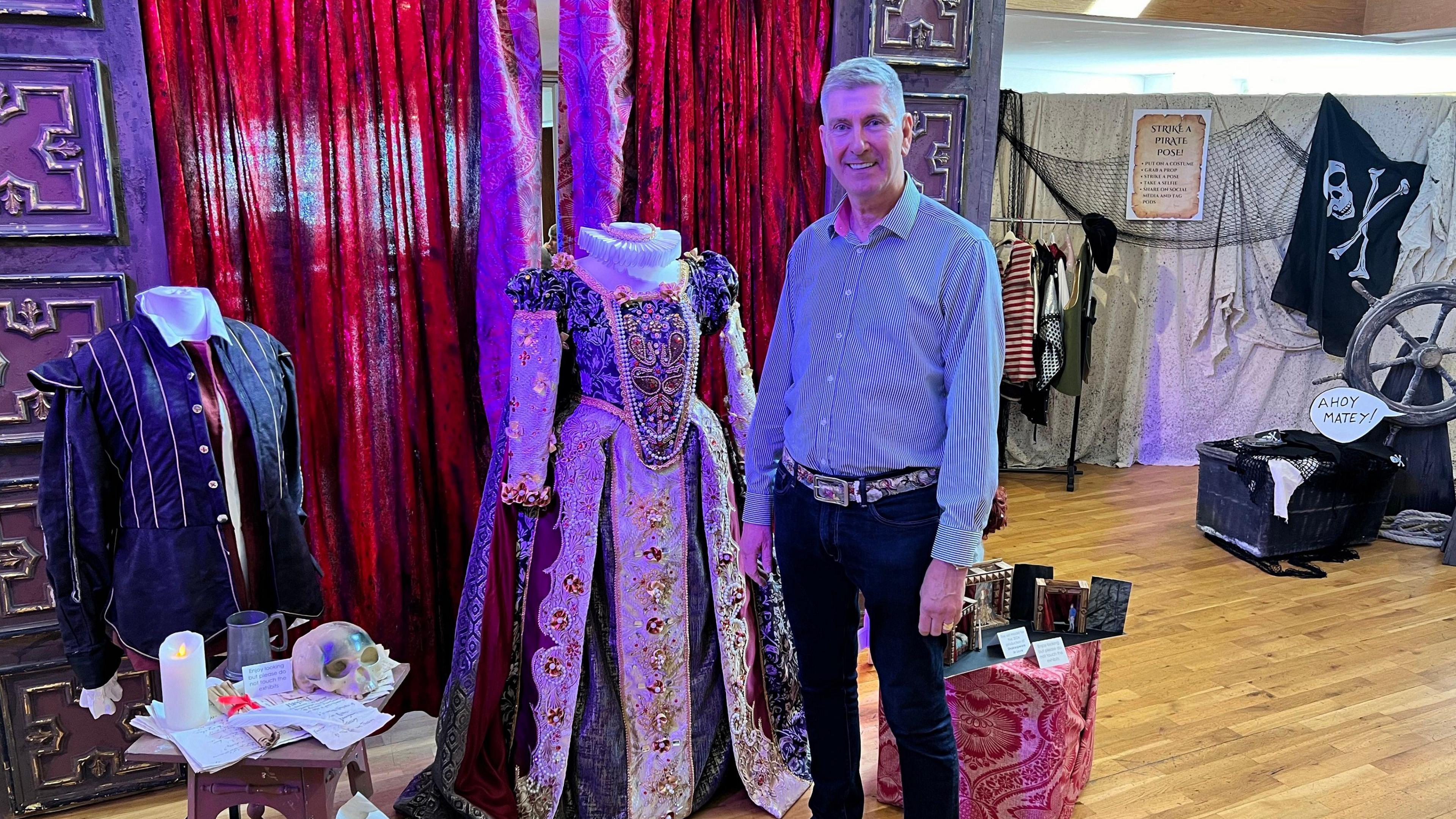 Andy Bradshaw stood in front of a dress he made for one of the group's performances