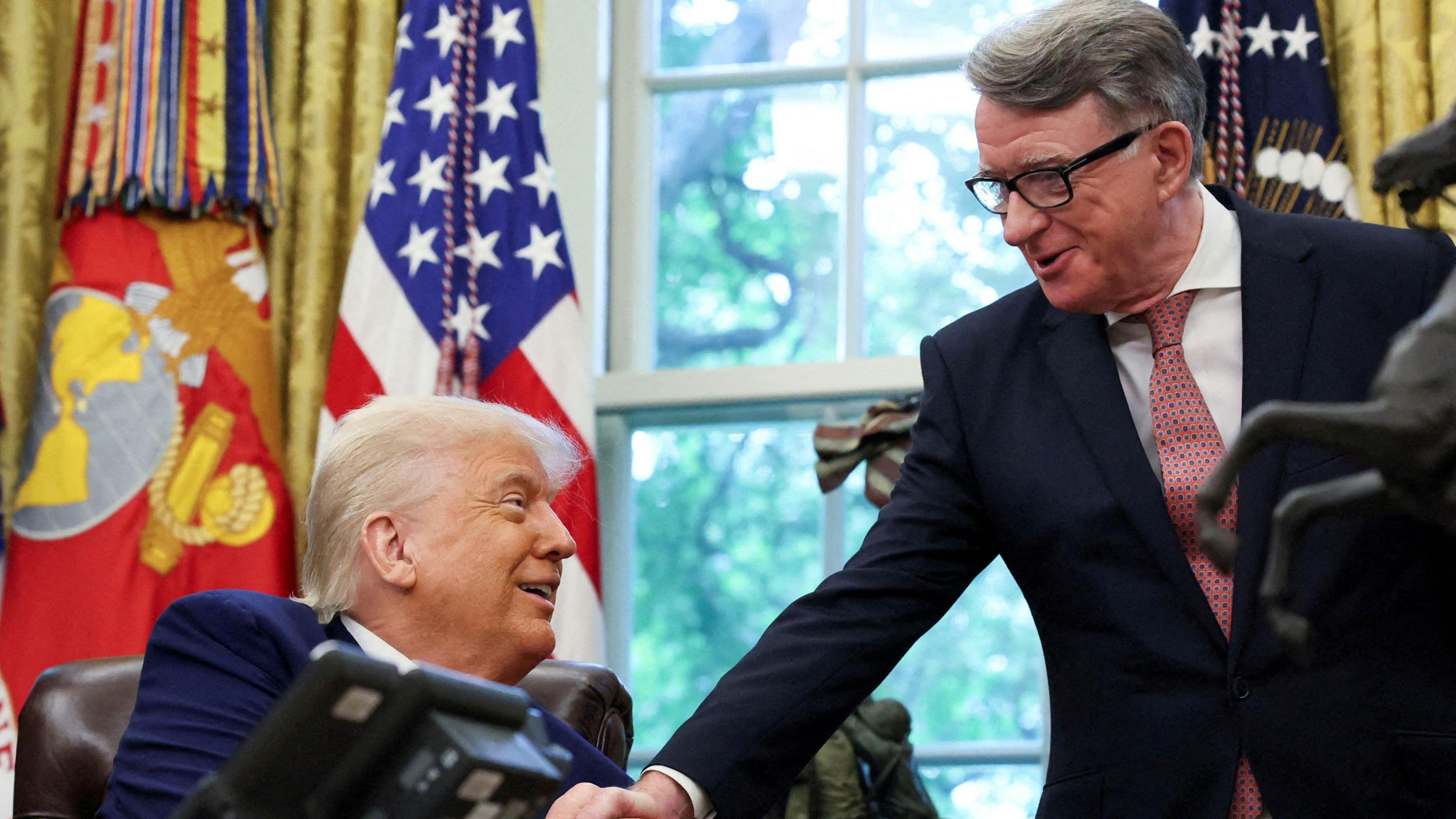 A smiling Donald Trump shakes hands with Mandelson in the Oval Office. 
