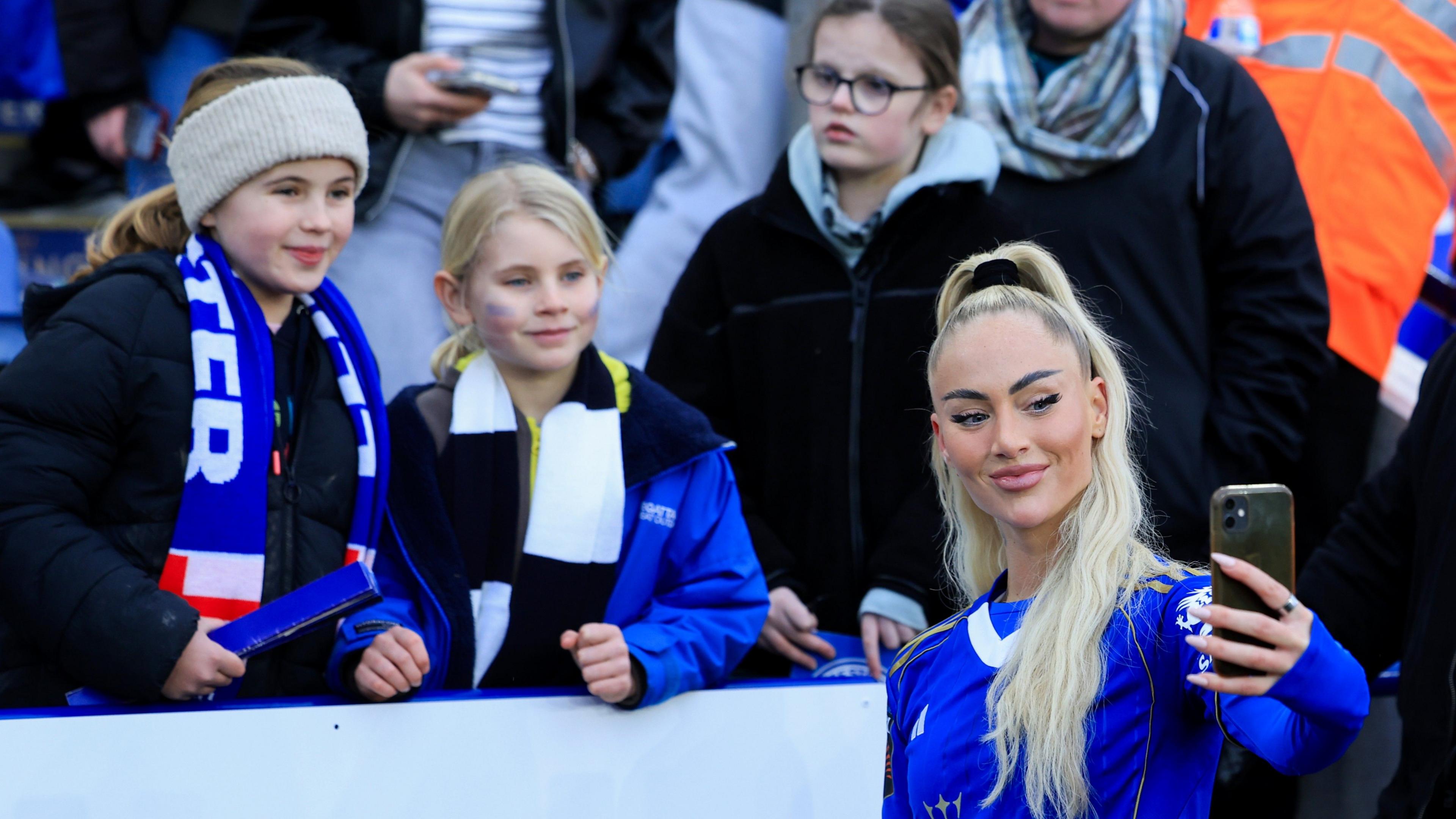 Alisha Lehmann takes a selfie with two Leicester-supporting children