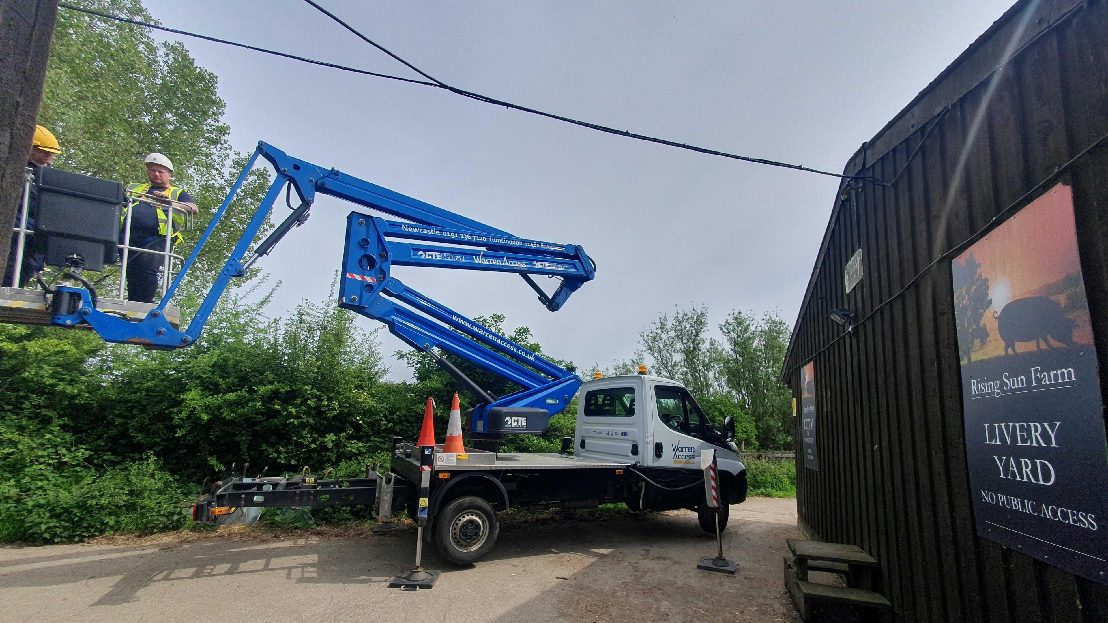 Blue crane with workmen installing the bird boxes. 