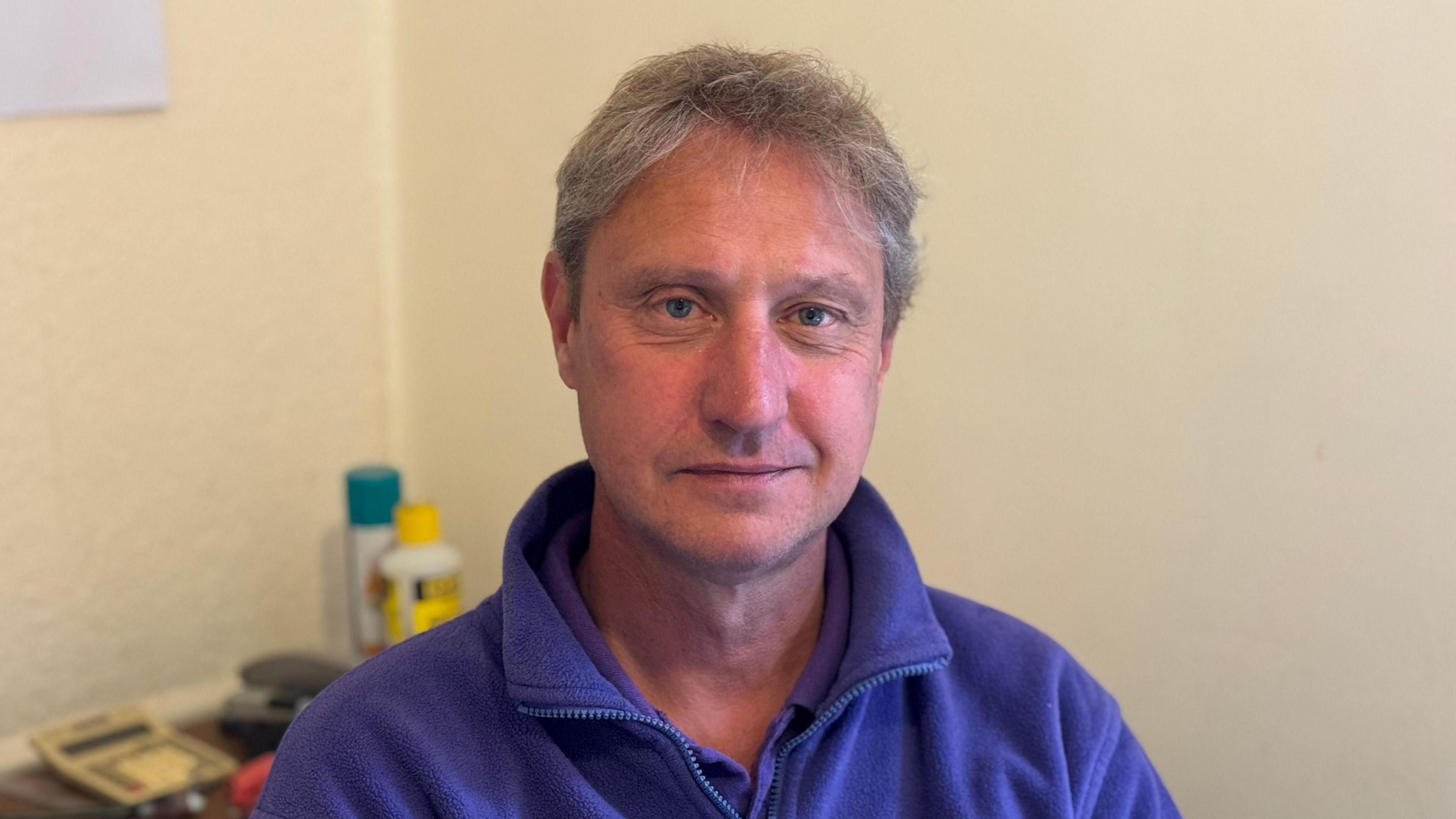 Nick Chaplin wearing a purple jumper while looking directly into the camera.