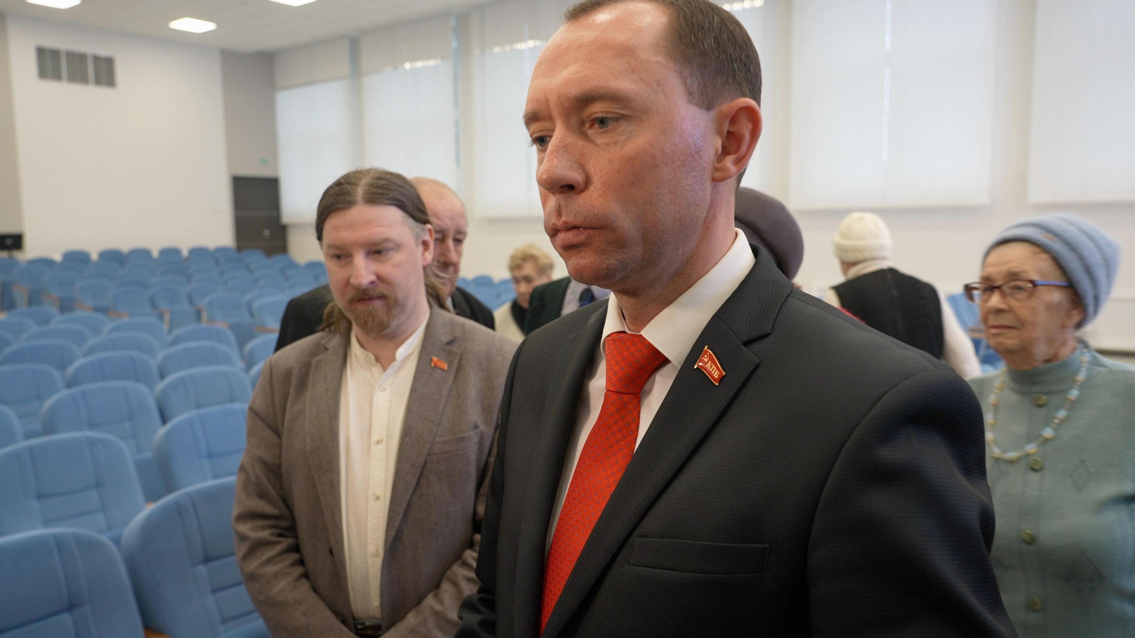 Sergei Syrankov wears a suit with a red tie and a Communist party pin.