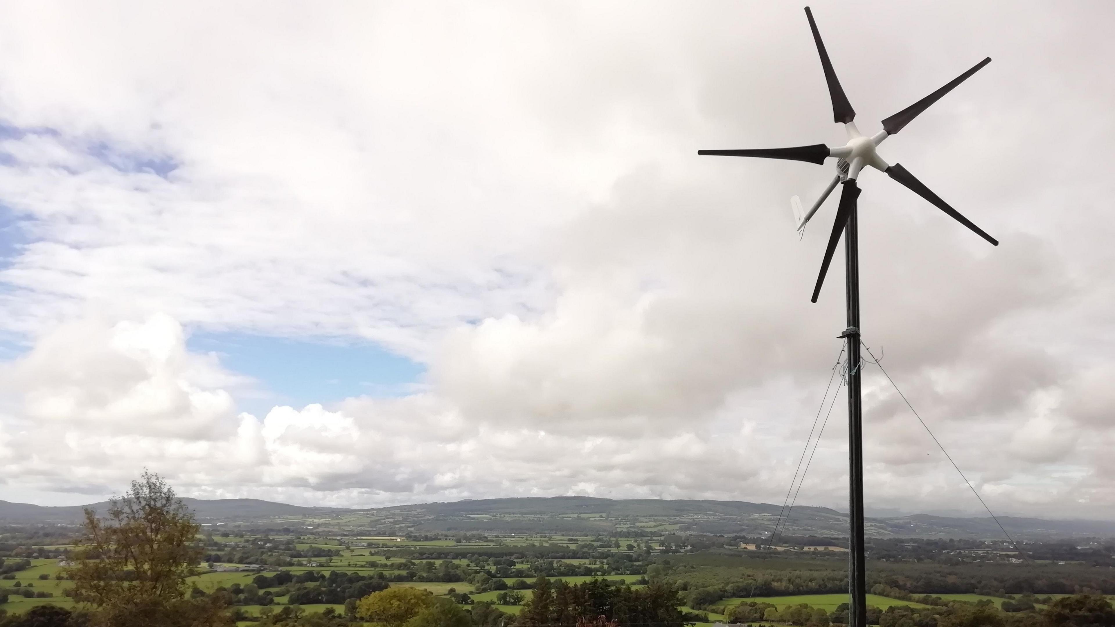 A small, five-bladed wind turbine in Michael Wilkinson's garden which overlooks green fields and hills in the Suir Valley, County Kilkenny 