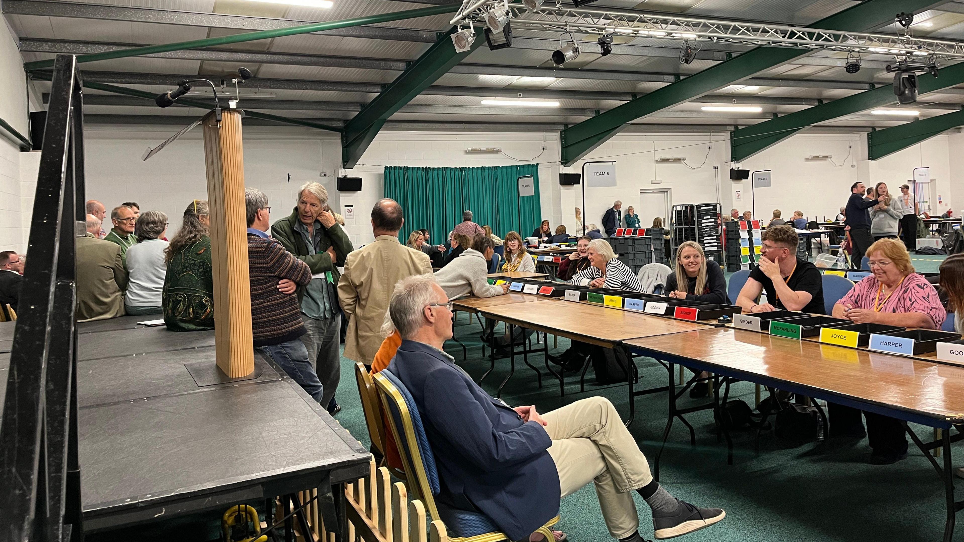 Shot of Forest of Dean MP count on July 4th 2024. Various people are seated in front of tables ready to count votes.