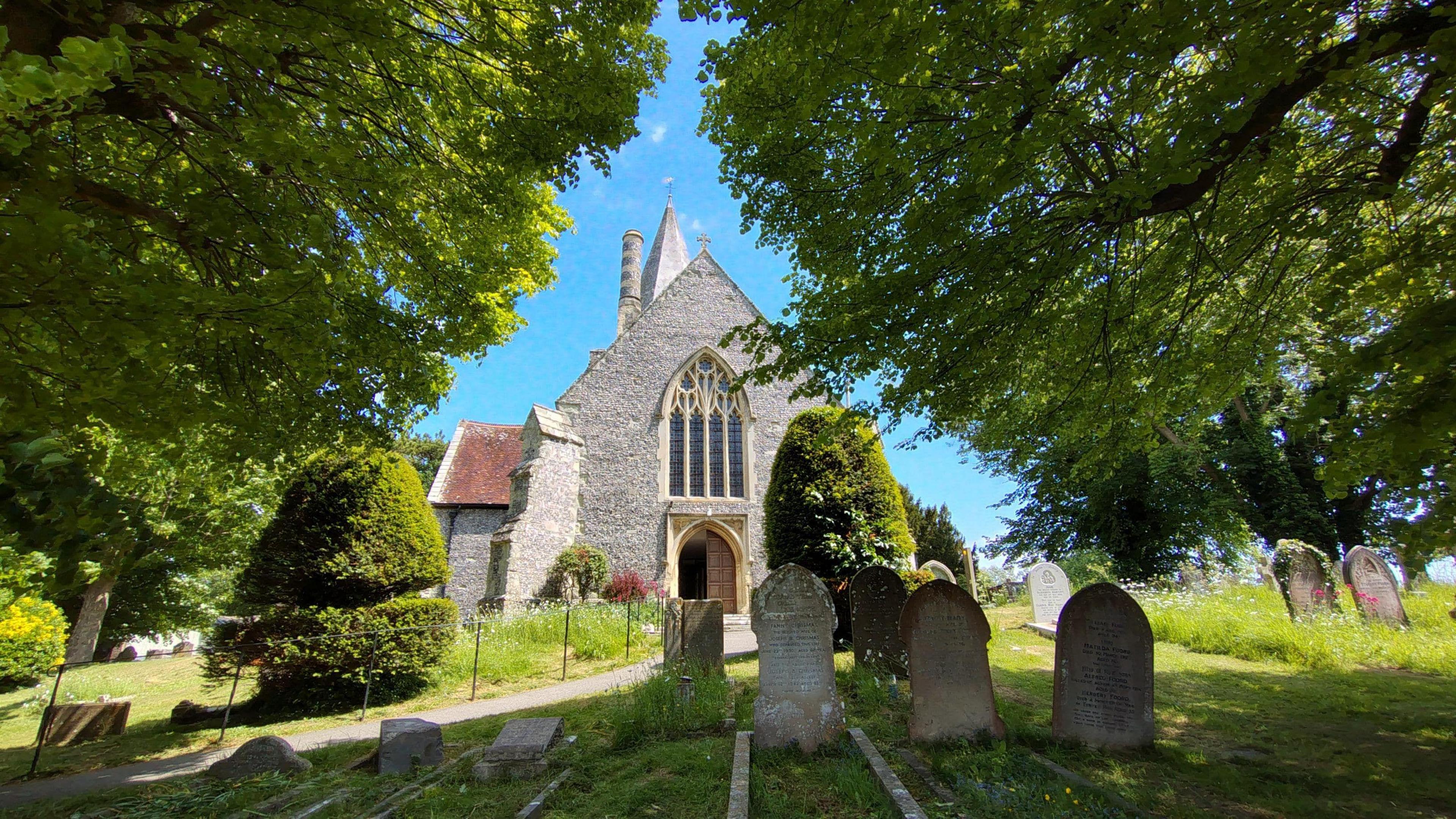 An exterior view of the front of 14th Century St Andrew's Church in Alfriston plus churchyard