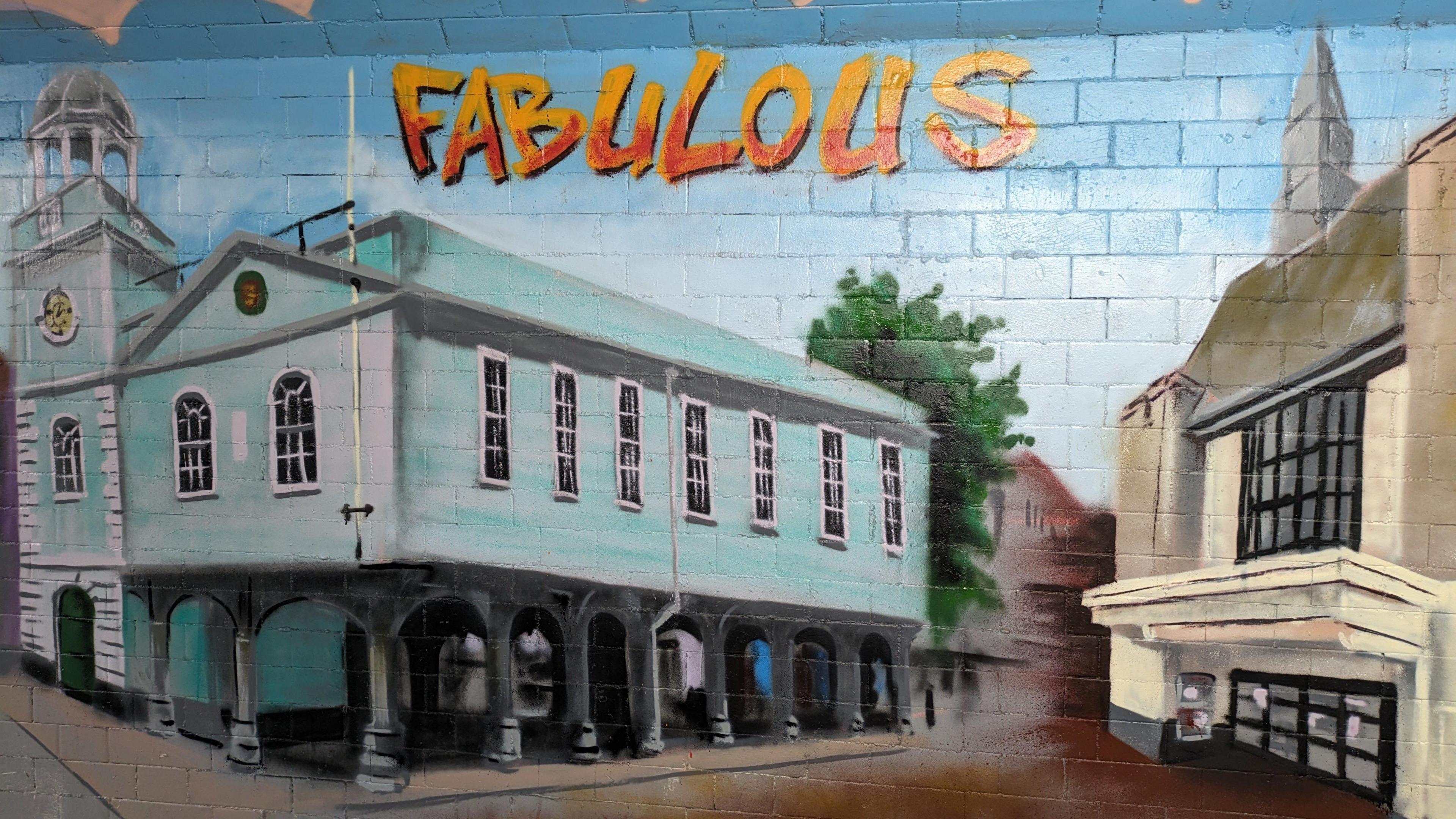 part of the mural, depicting a large green building with arches in the town of Faversham, with "Fabulous" painted above it.