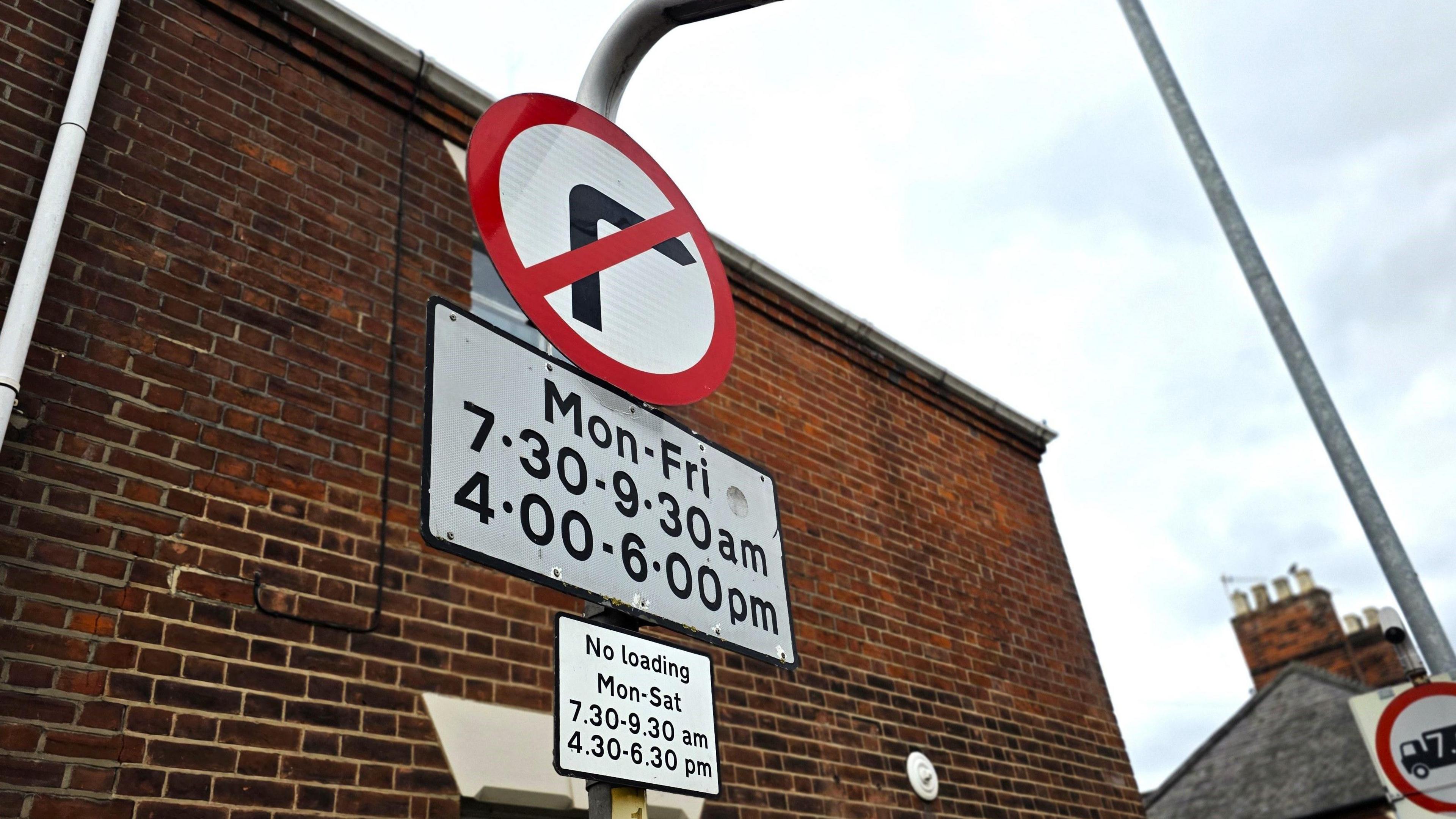 We can see a road sign prohibiting a right turn. It says Mon-Fri - 7.30-9.30am, 4.00-6.00pm
