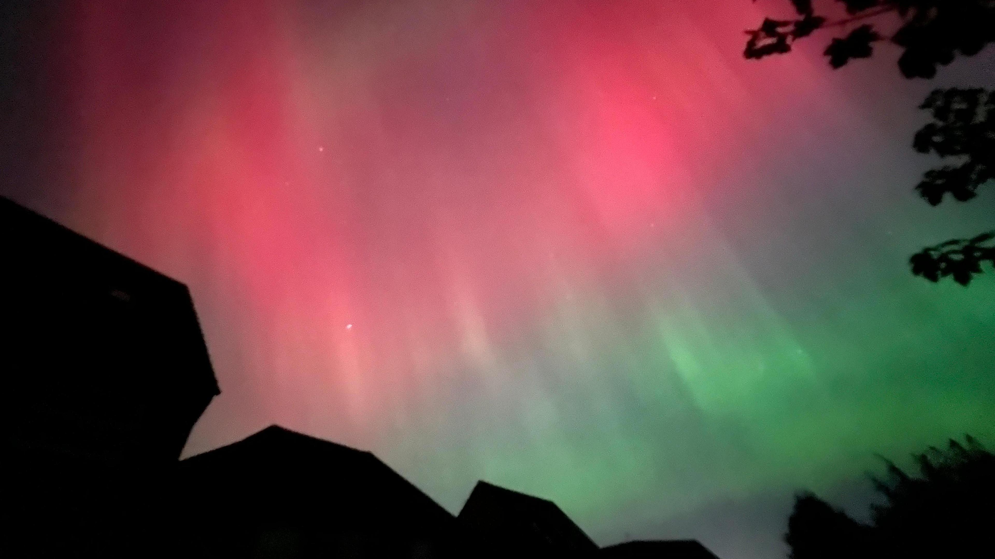 Houses in Mansfield, silhouetted against the colours of the northern lights