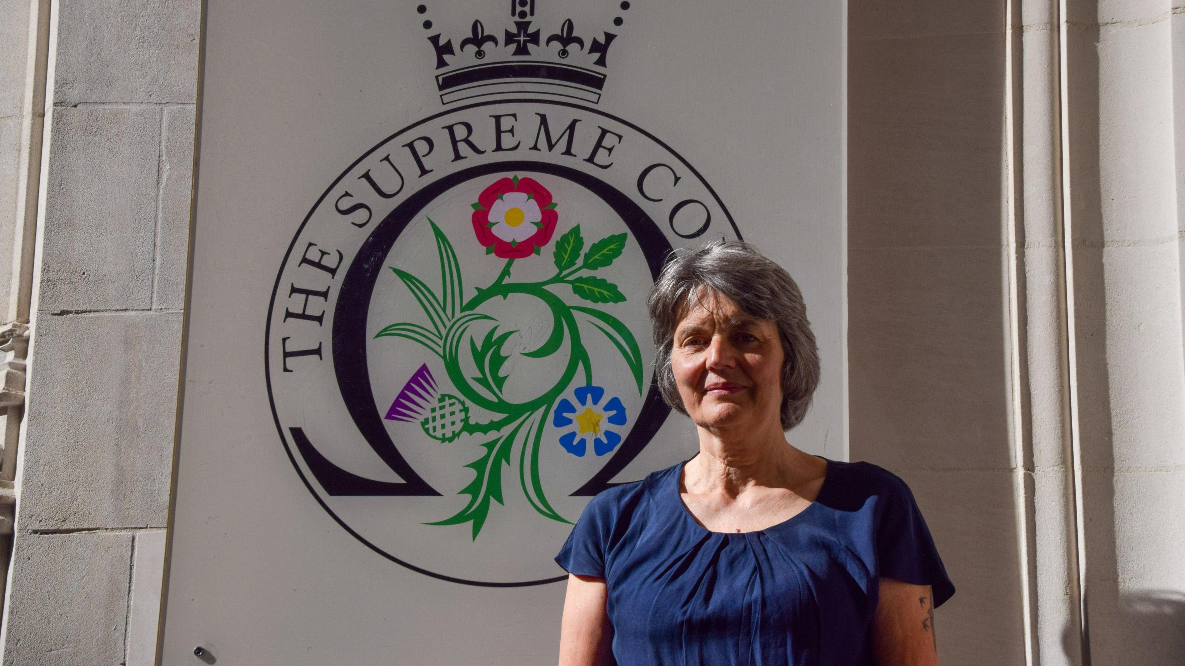 Campaigner Sarah Finch standing outside the Supreme Court, wearing a short-sleeved blue top.