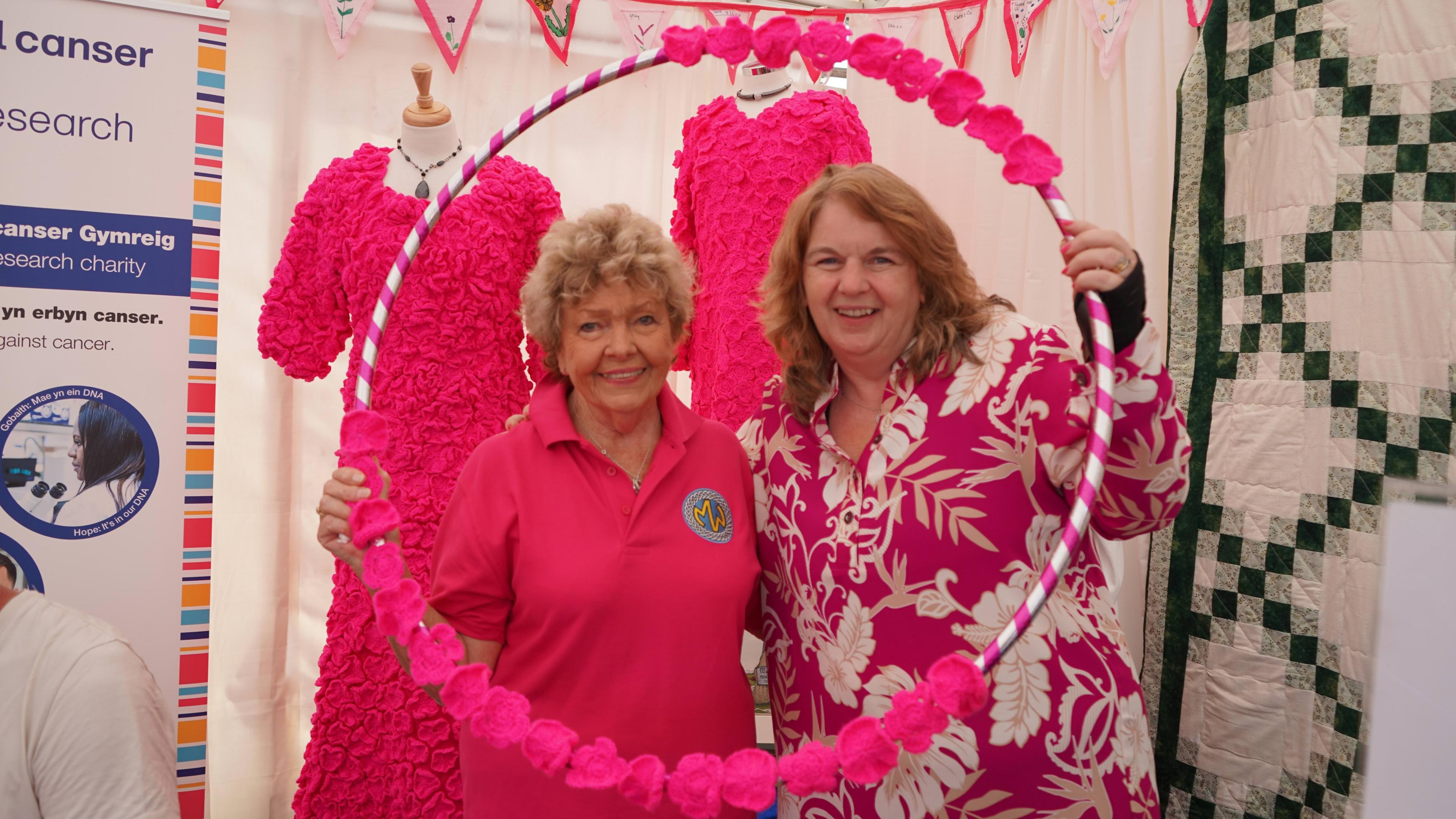 Margarette Hughes, Llywydd Anrhydeddus Merched y Wawr o Hendy-gwyn ar Daf a Tegwen Morris, cyfarwyddwr y mudiad yn llawn positifrwydd pinc ar eu stondin