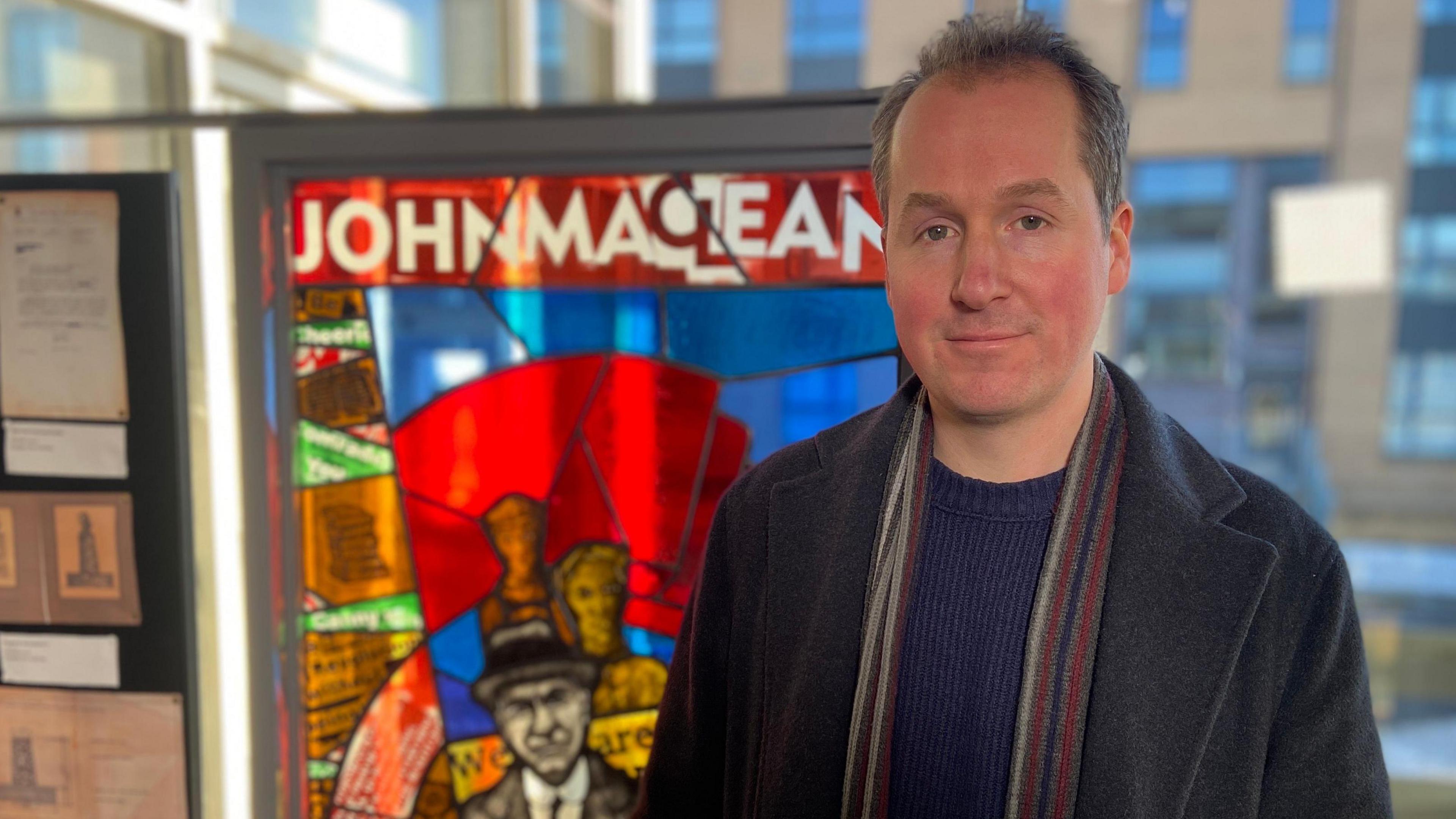 Author Henry Bell, next to the John Maclean stained glass window tribute in Pollokshaws Library.